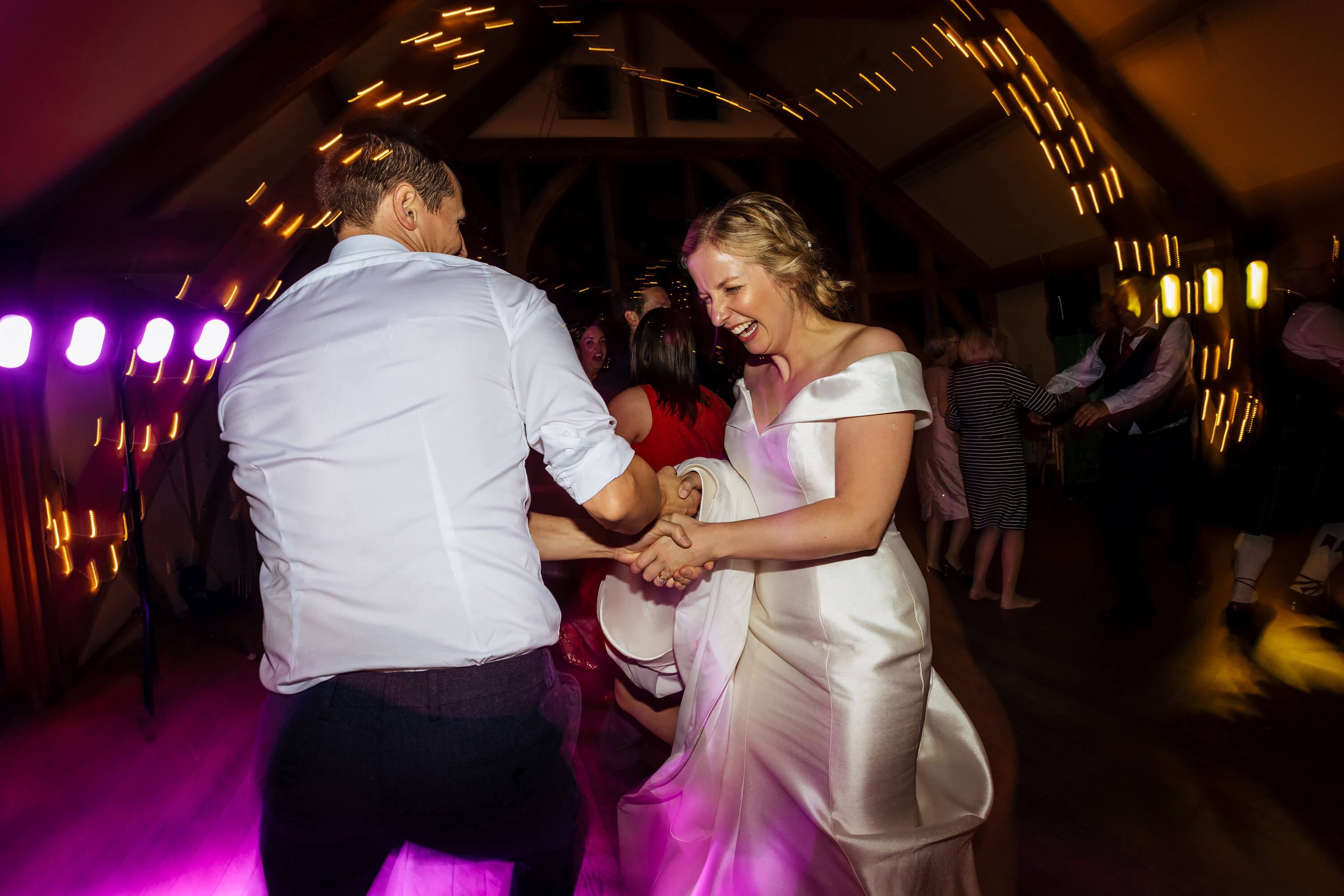 Bride and groom ceilidh dancing at a Sandburn Hall wedding