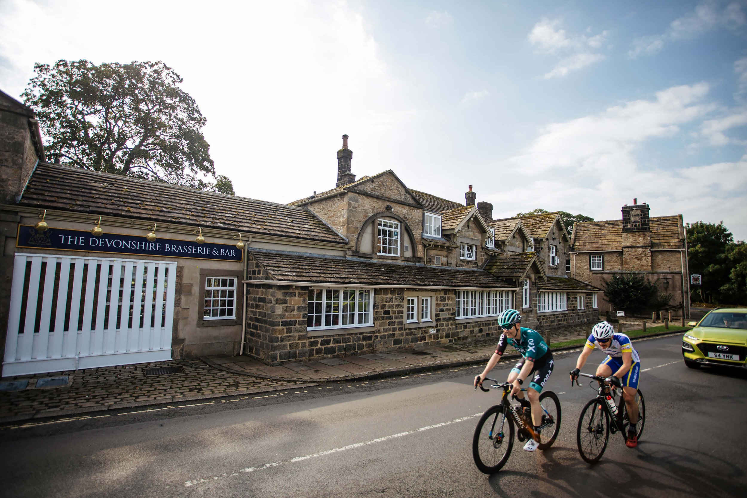 Cyclists passing the Devonshire Arms on a sunny Yorkshire day