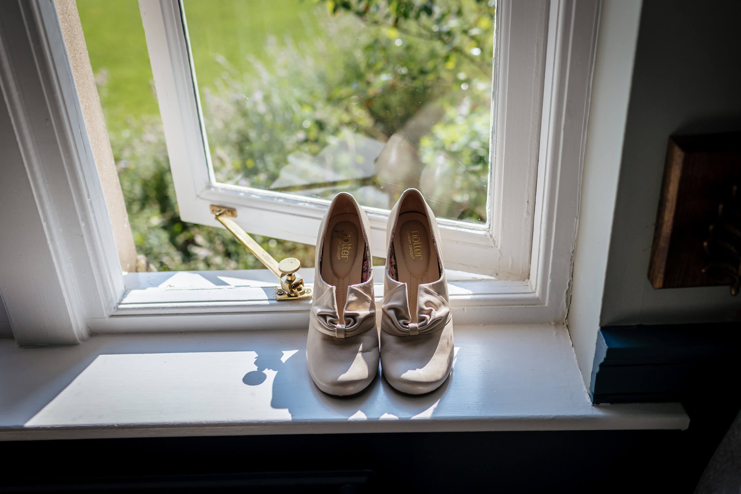 Wedding shoes sitting in the window on a sunny day