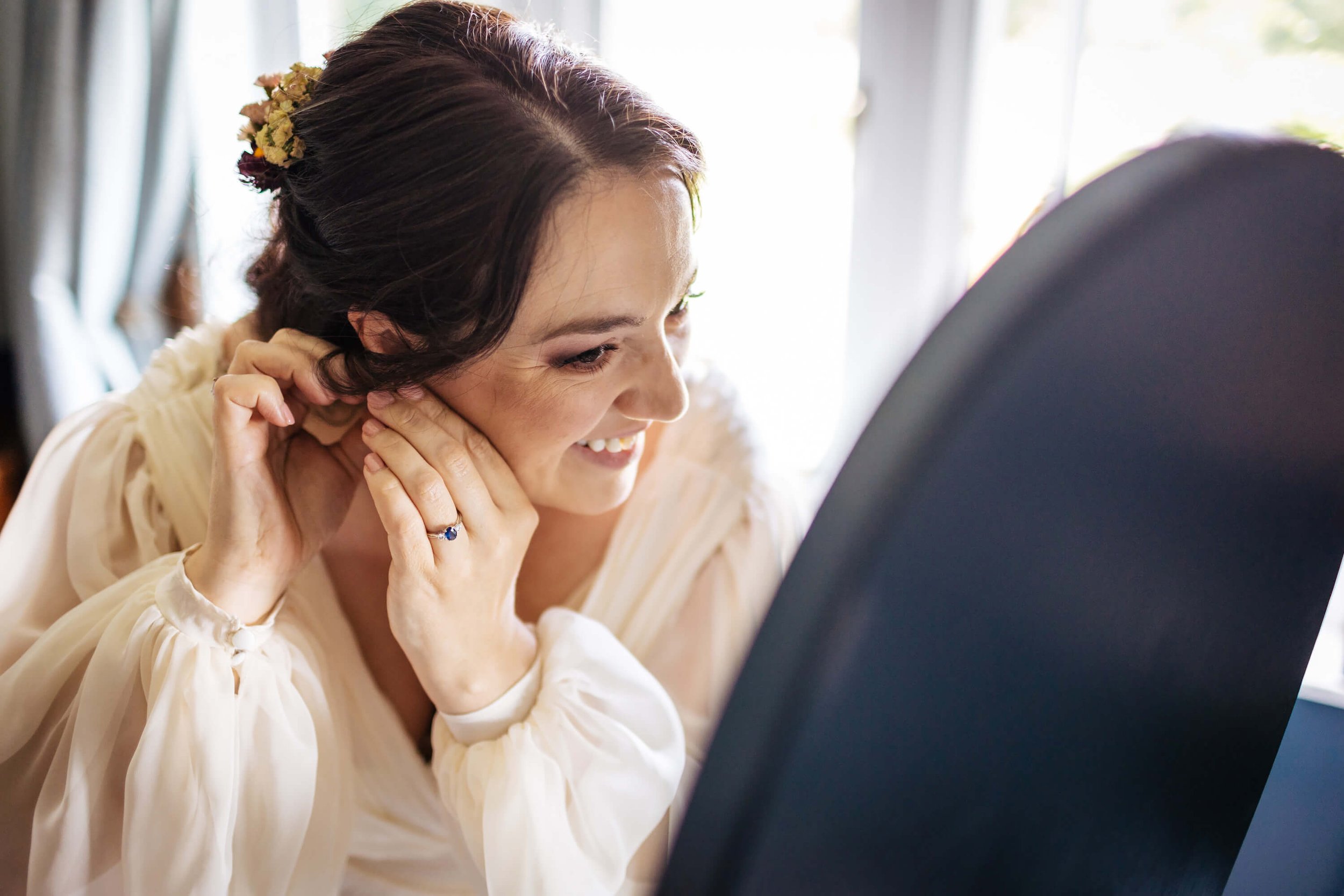 Bride puts on her earrings before the wedding in Yorkshire