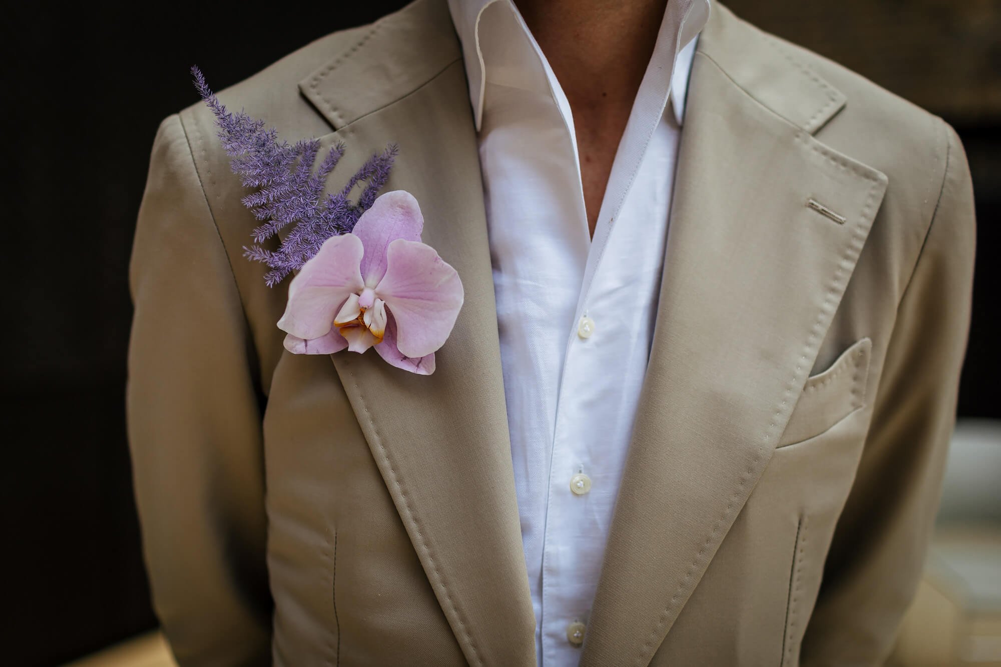 Close up of the groom's suit and buttonhole at a wedding