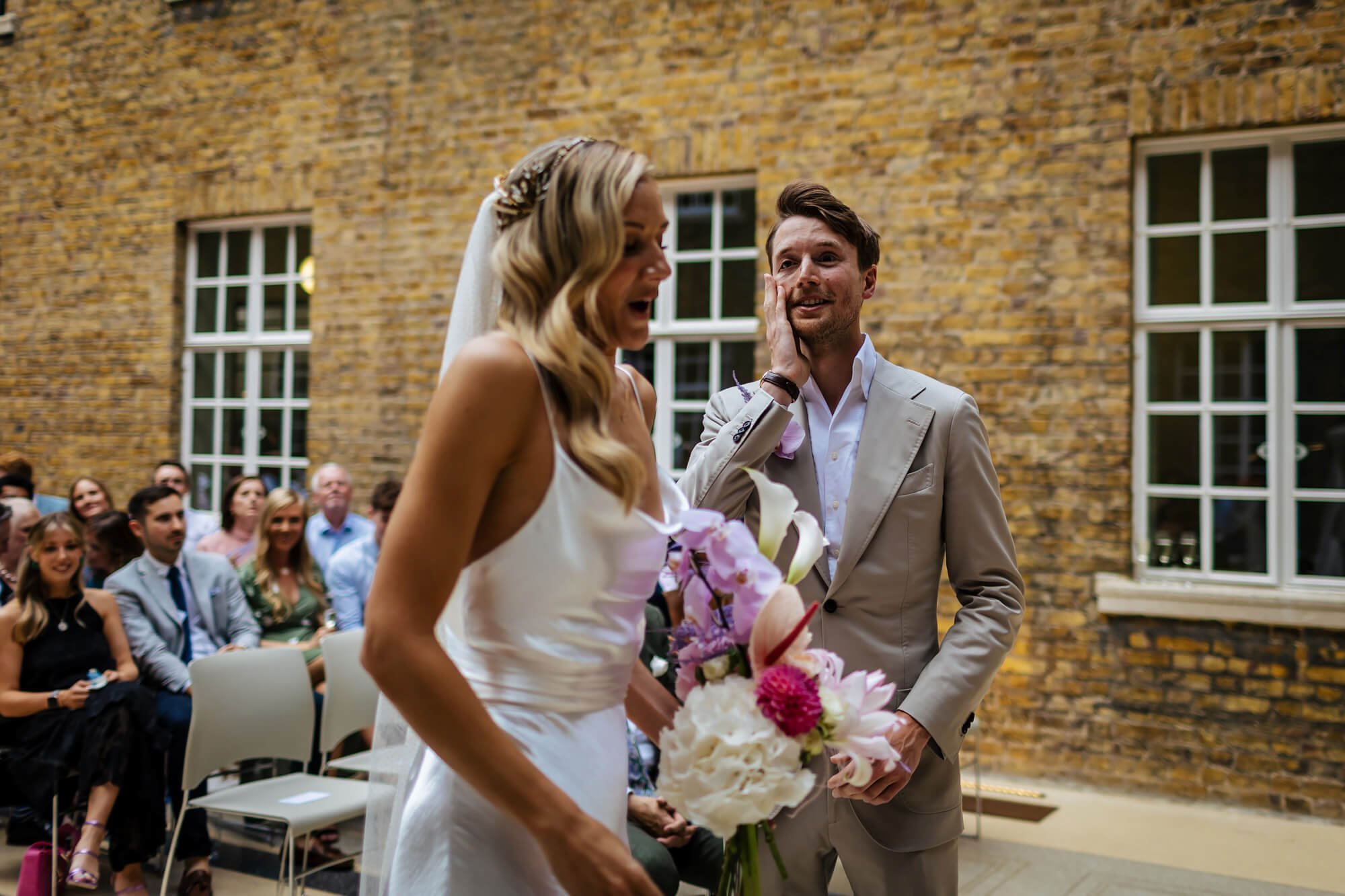 The groom looking amazed at how beautiful his bride is