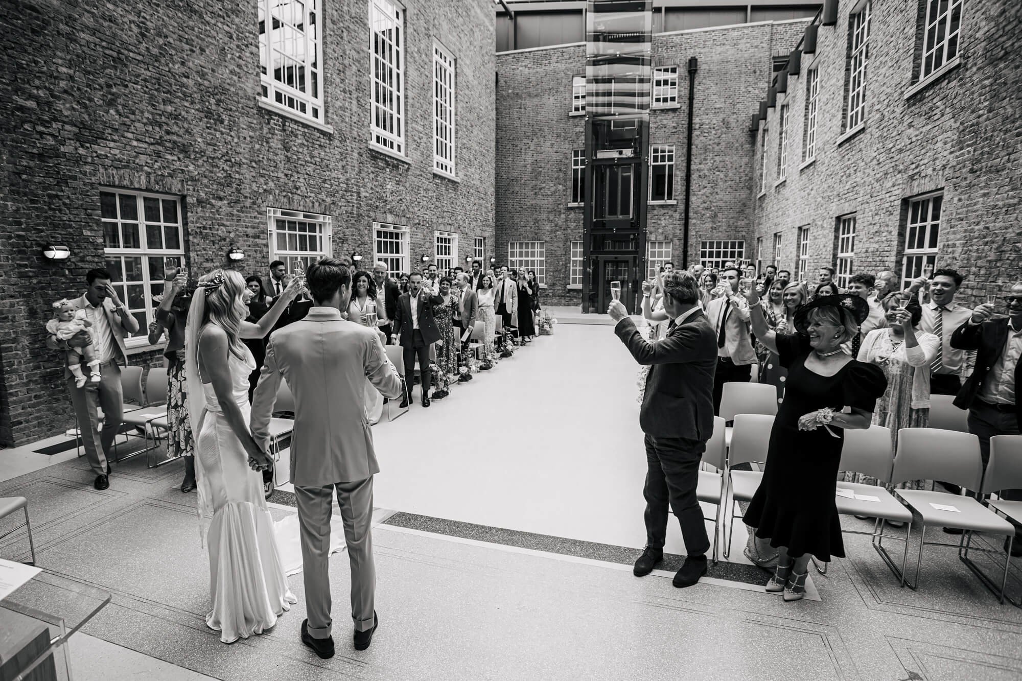 Wedding guests cheer the couple with a toast