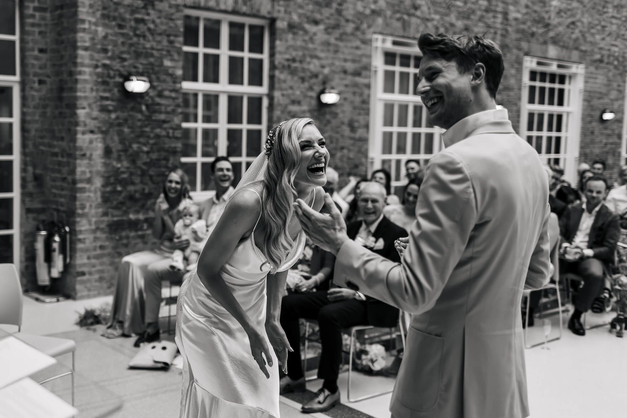 Bride laughing at the groom during the wedding vows