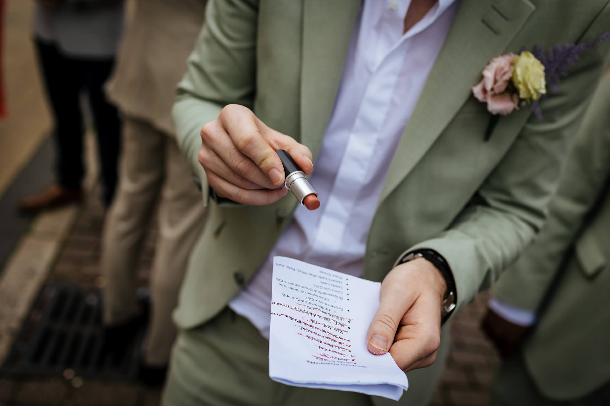 A man holds a lipstick to cross off the photo list