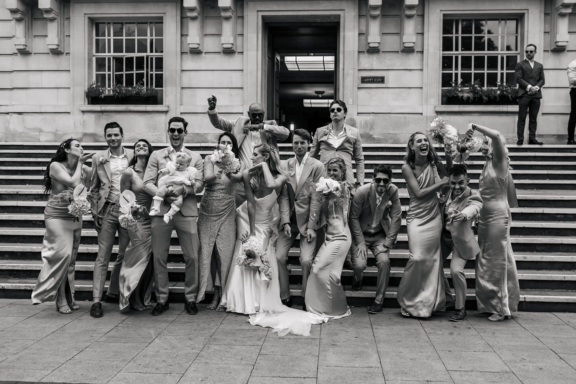 Bridesmaids and groomsmen pulling funny shapes outside of the wedding