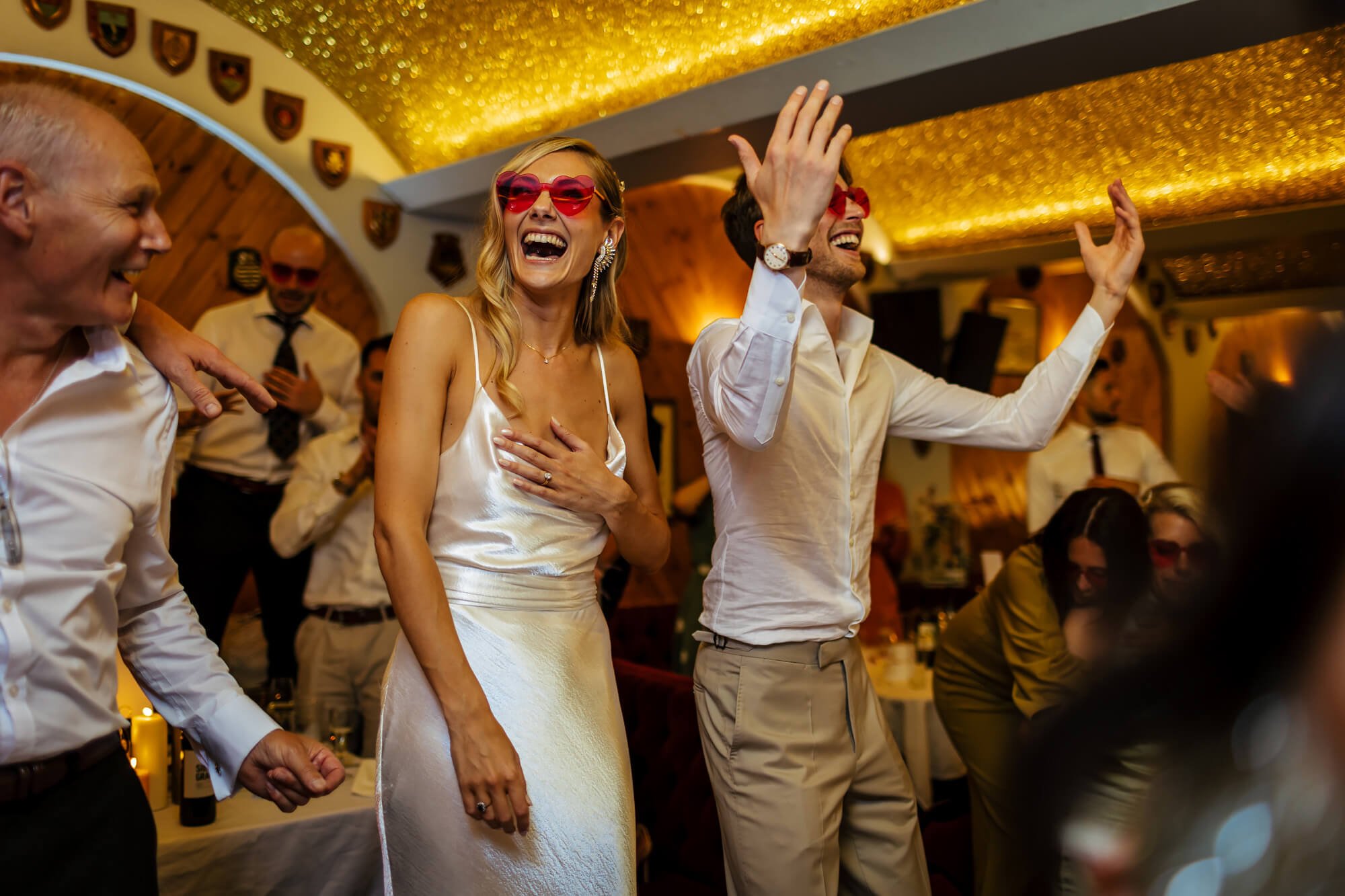 Bride wears heart sunglasses at her wedding reception
