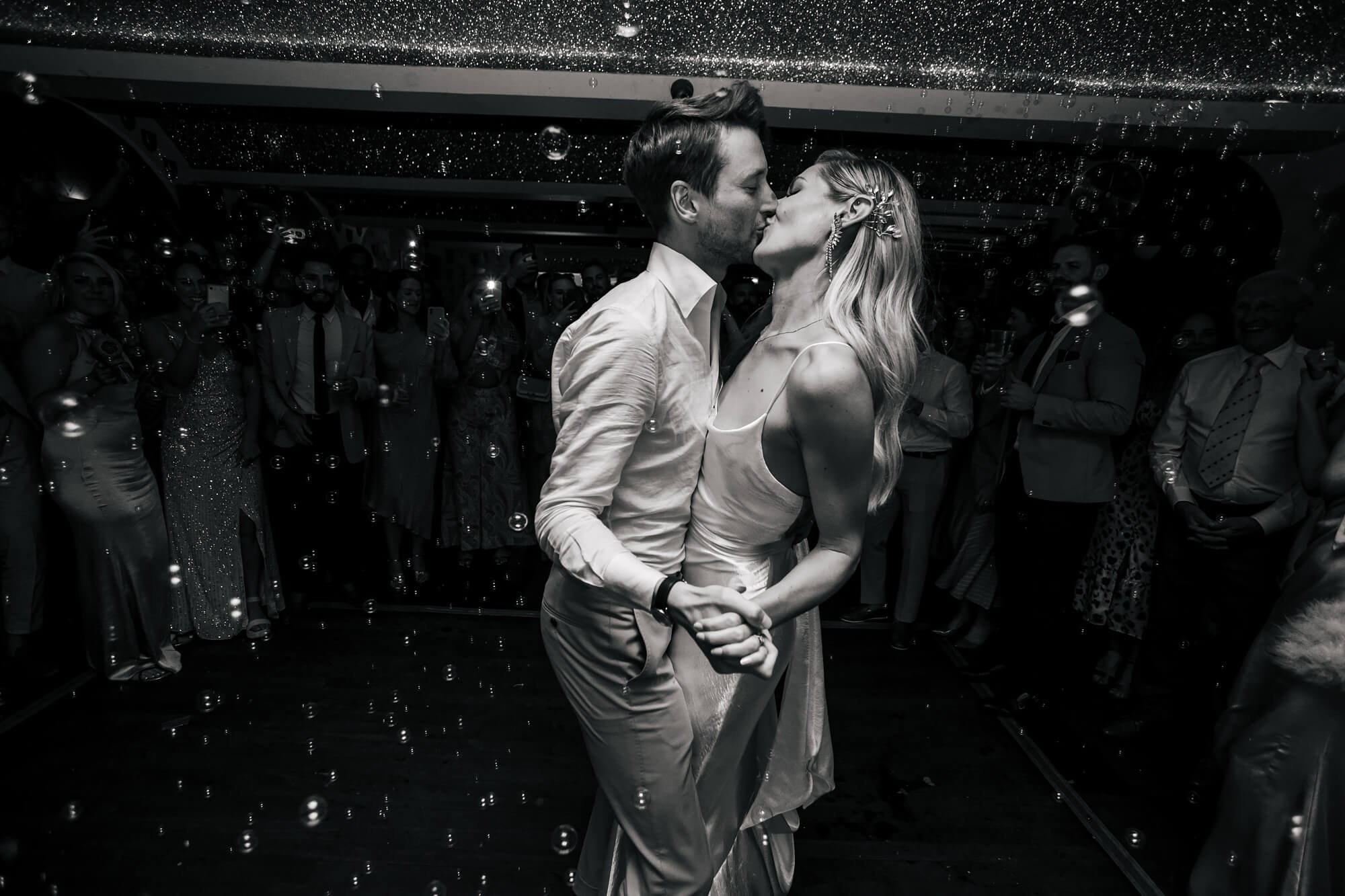 Bride and groom share a kiss at the first dance in the evening 