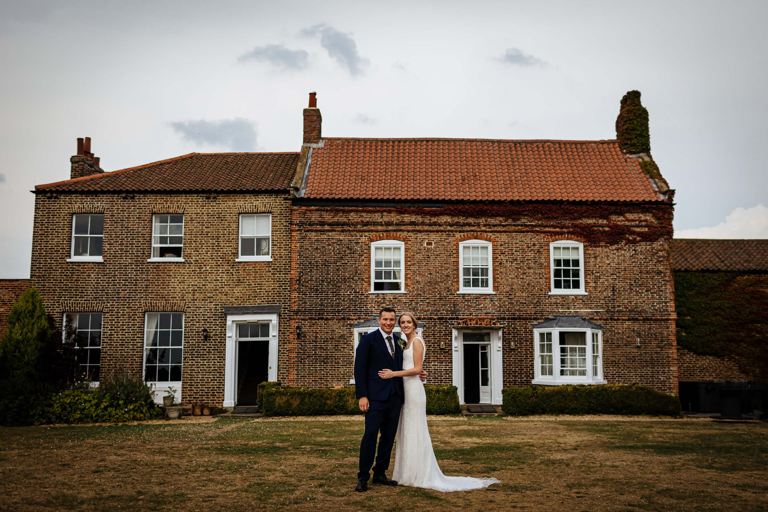 Bride and groom standing in front of Hornington Manor at their wedding