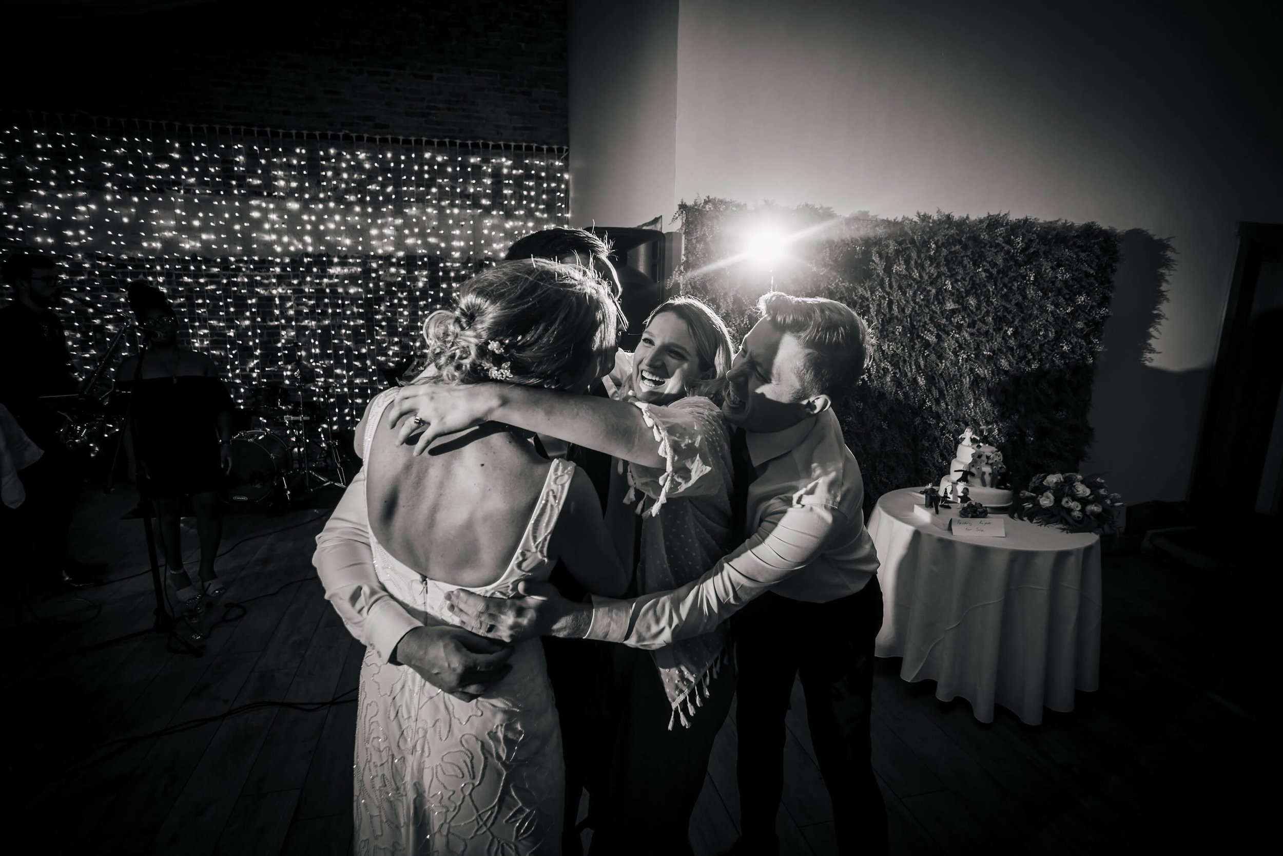 Wedding guests group hug at a wedding in the evening