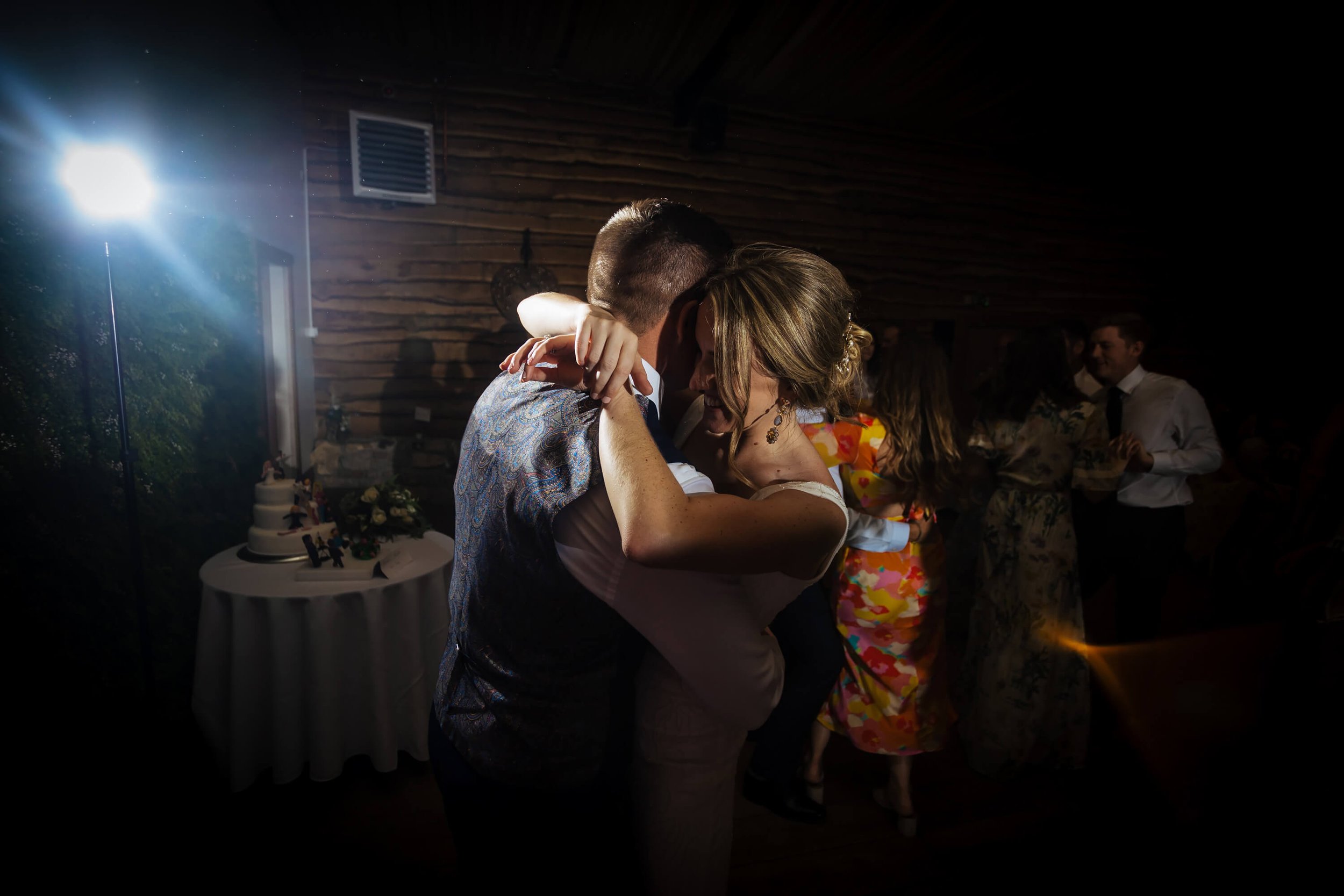 Bride and groom share a hug on the dance floor