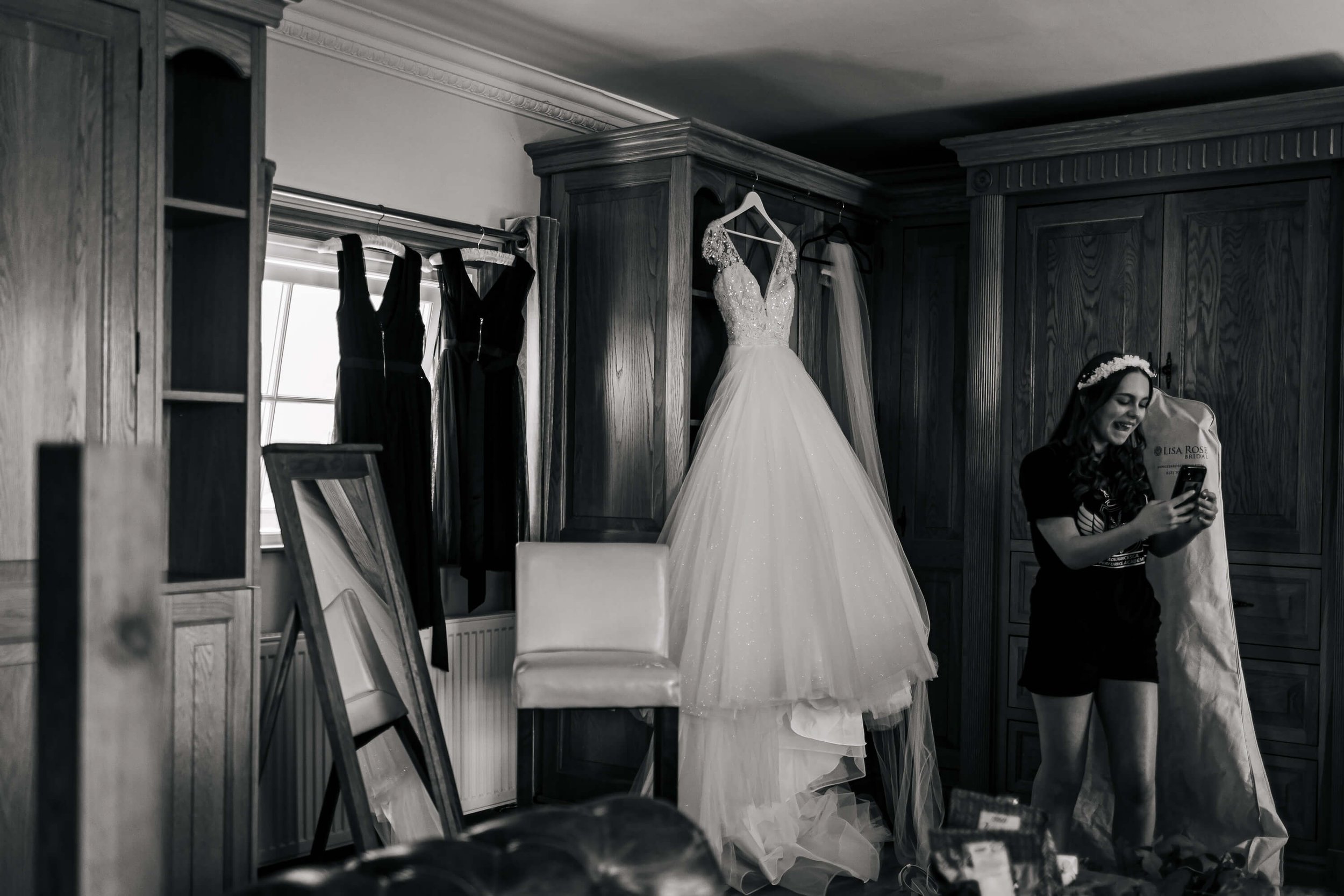 The bride's wedding dress hanging up on the wardrobe