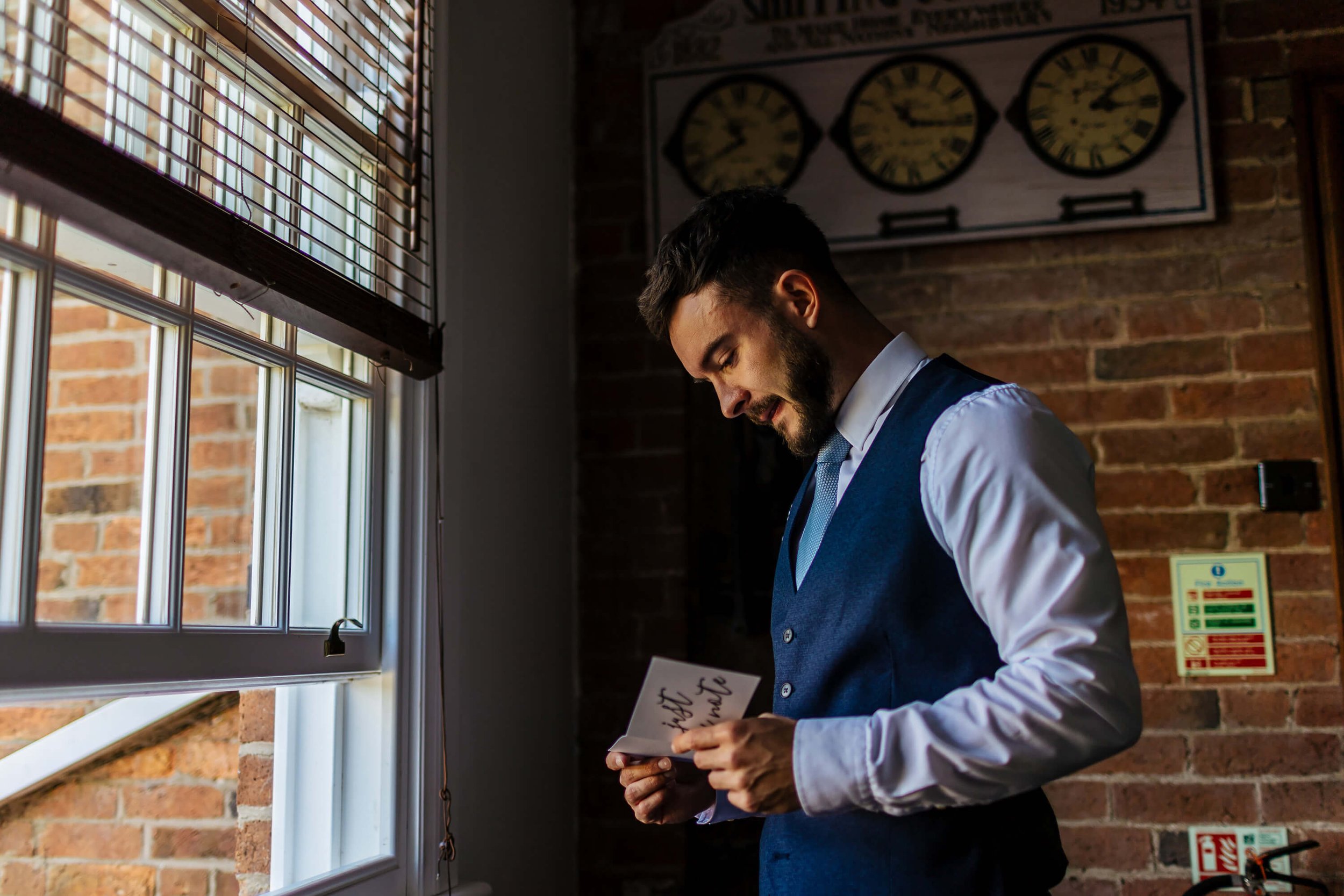 Groom reading a card from his wife on the morning of the wedding