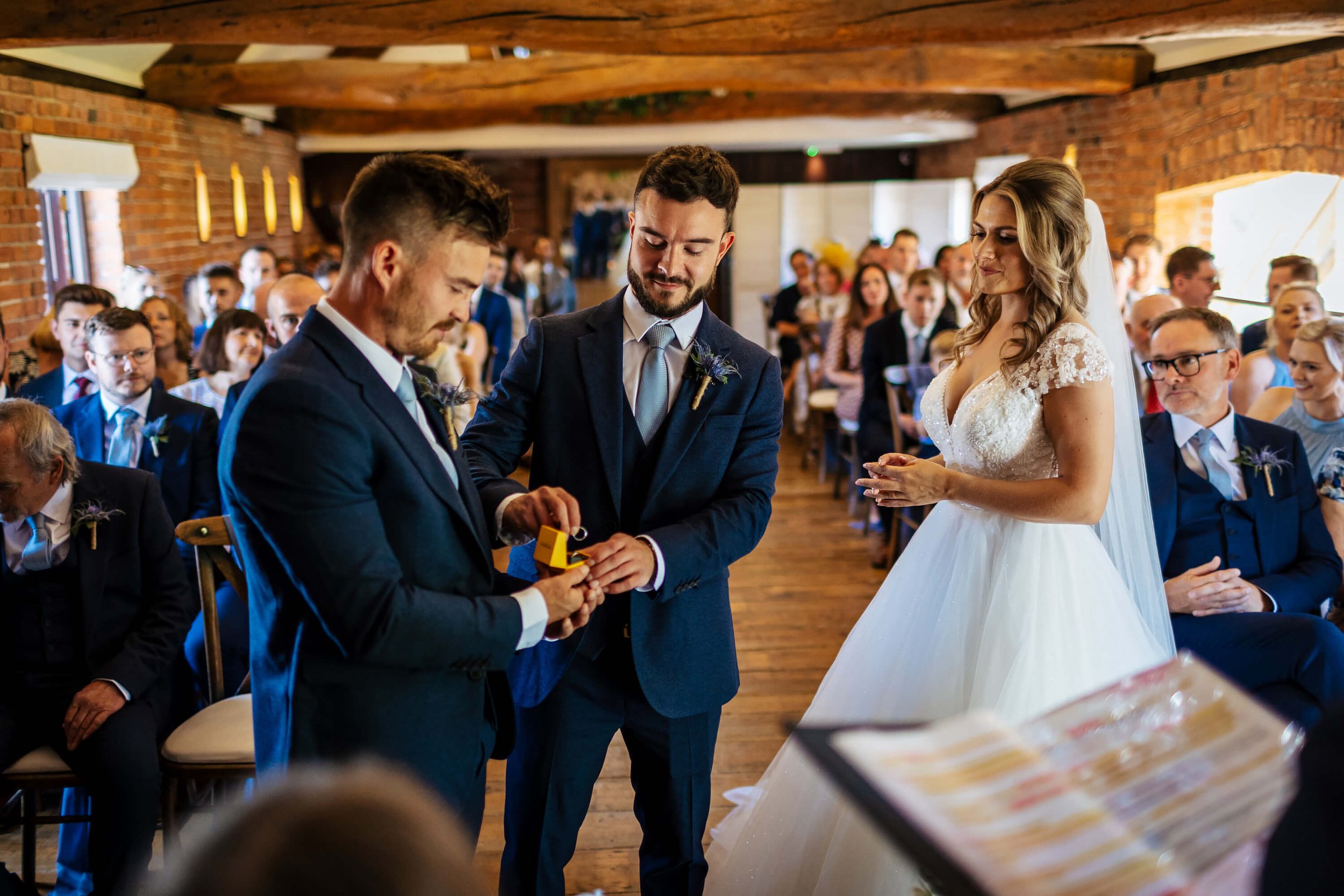 Best man hands the wedding ring to the groom during the ceremony