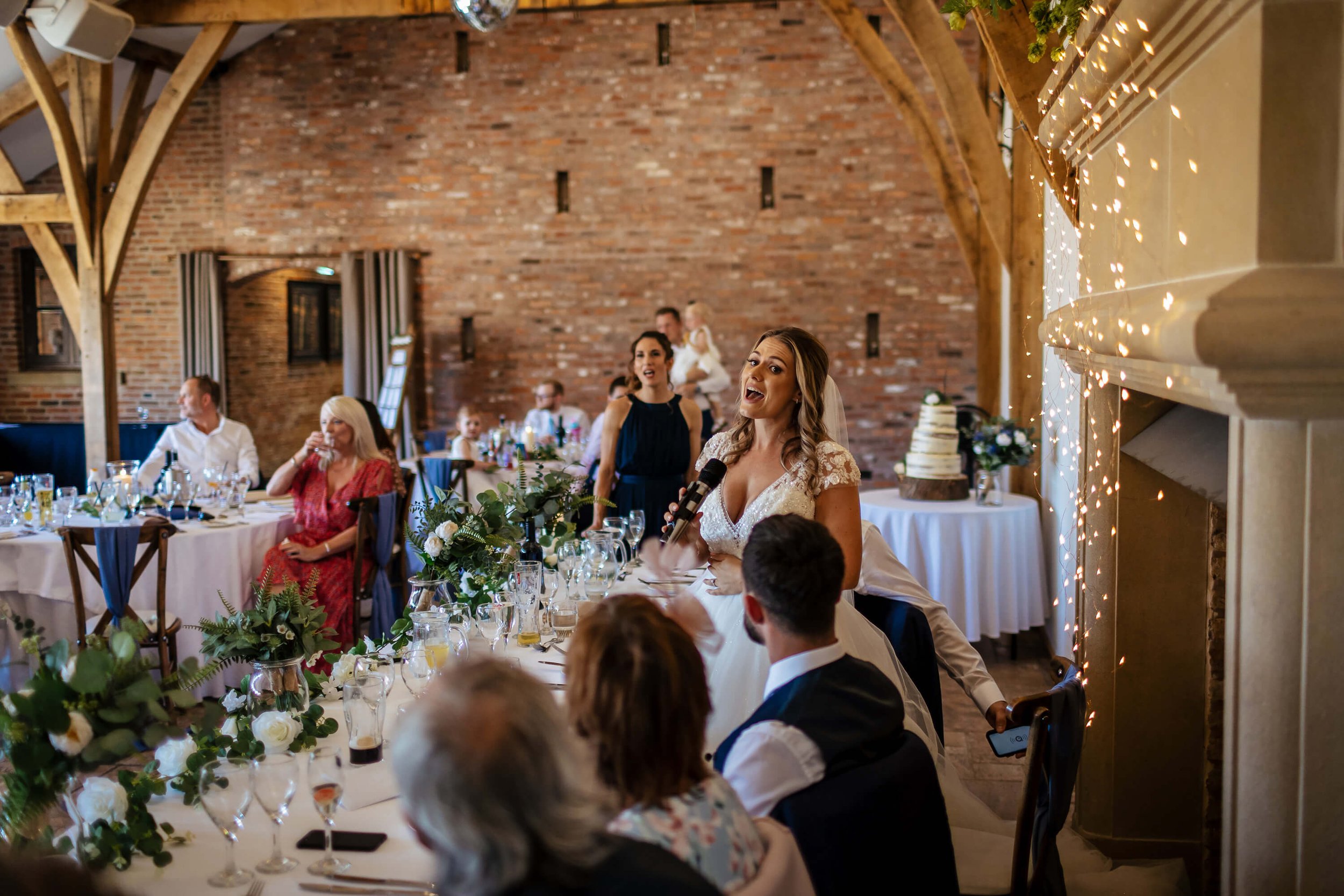 The bride singing during the speeches at her wedding at Swancar Farm