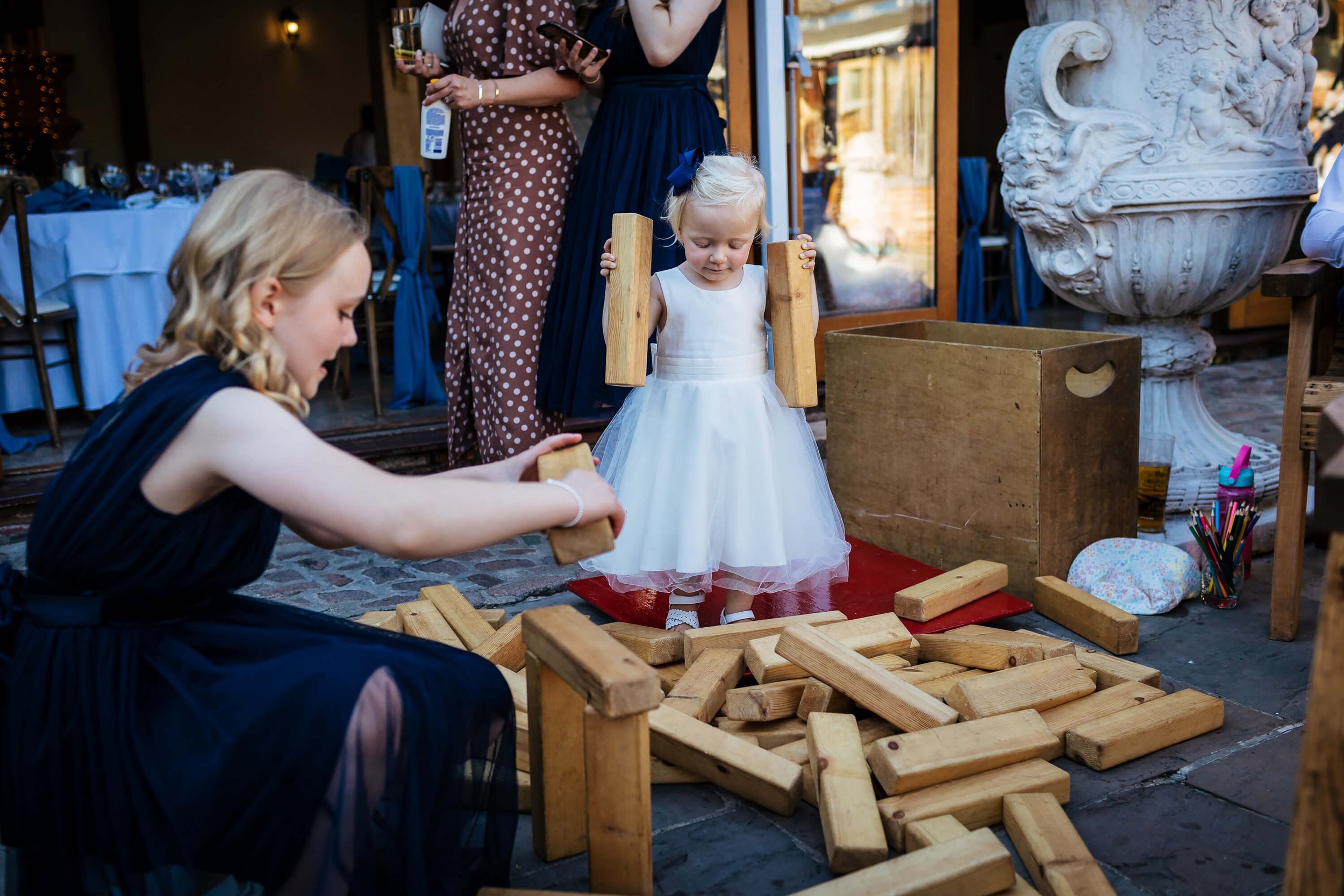 Young girl playing jenga at a wedding in the sunshine