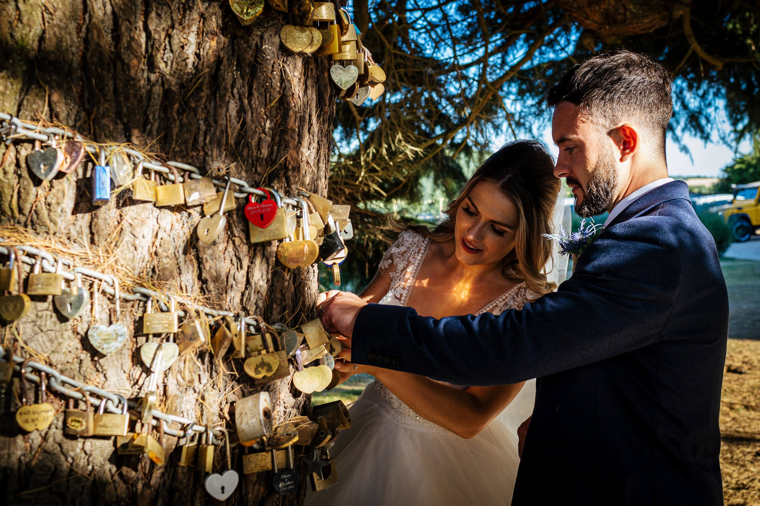 Bride and groom attaching a locket to the tree at Swancar Farm