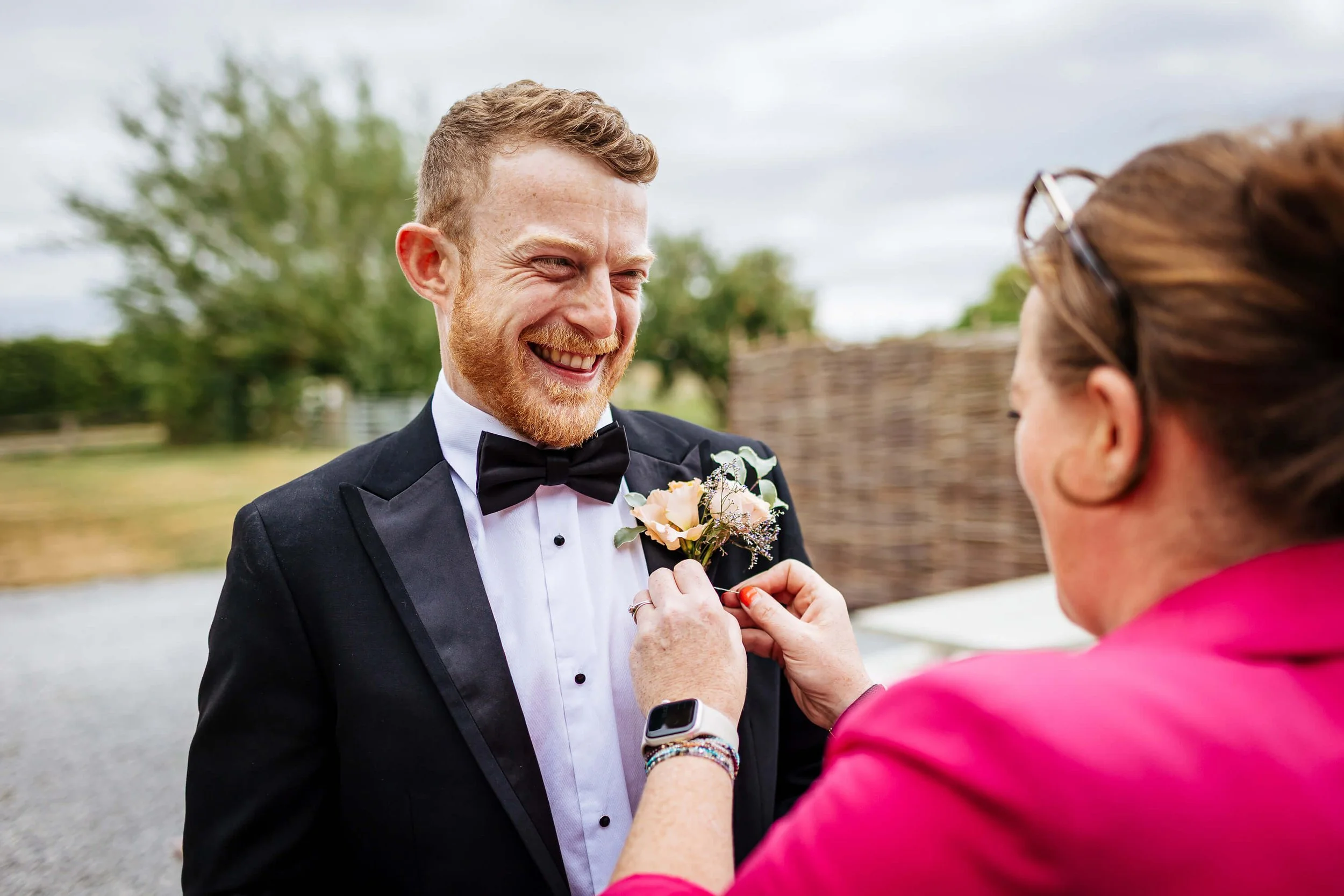 Groom has his flower attached on his wedding morning