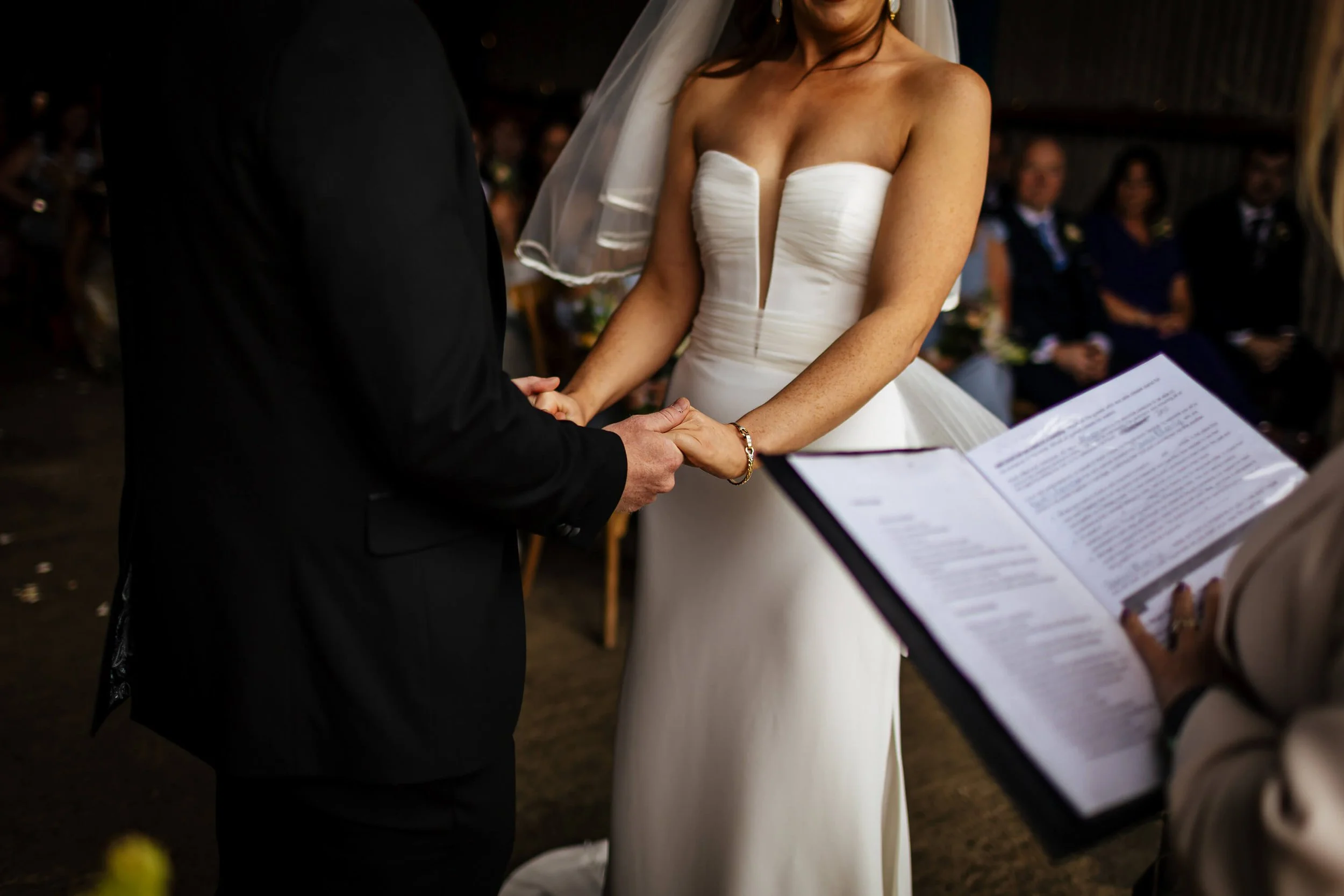 Bride and groom hold hands at their wedding ceremony