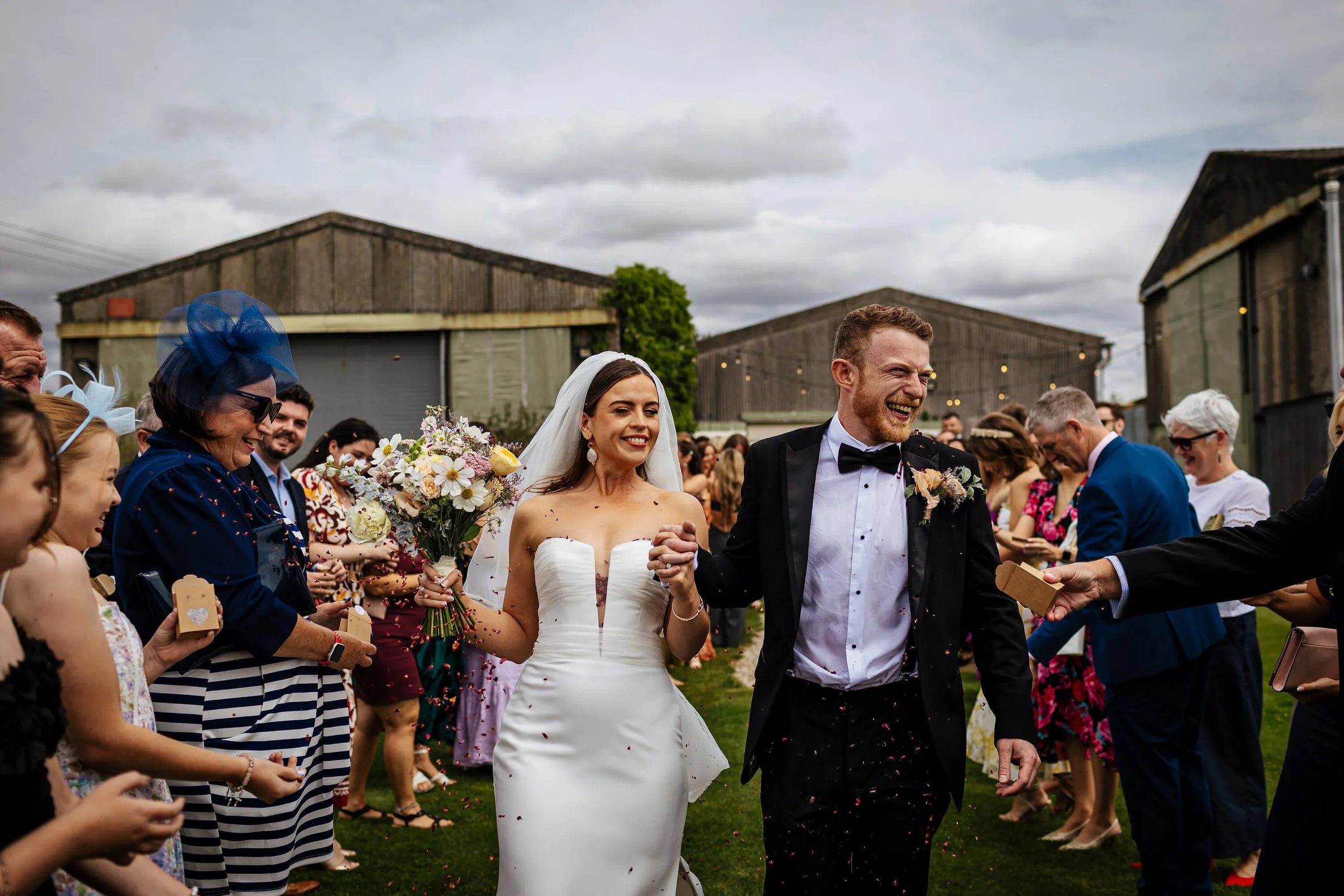 Wedding guests throwing confetti over the newlyweds