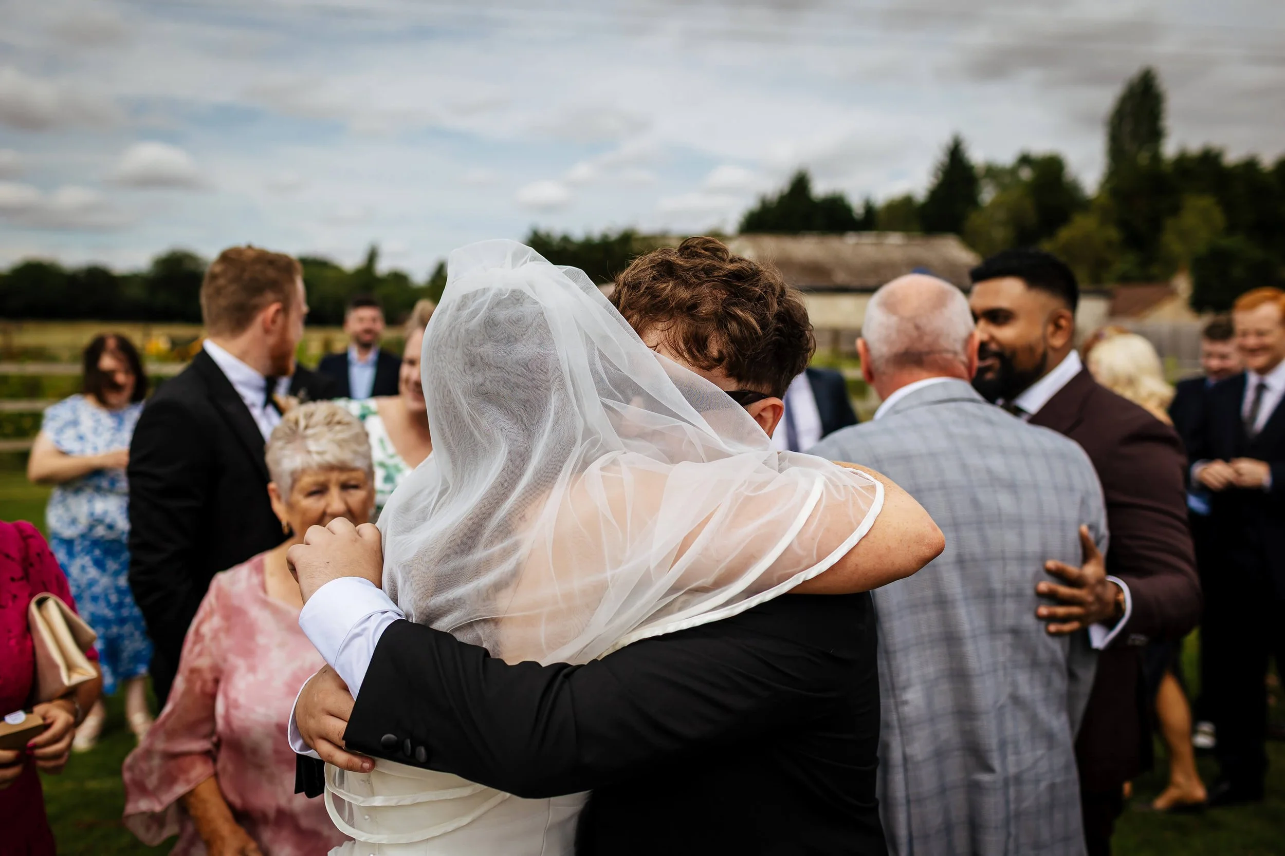 Guest hugs the bride on her wedding day