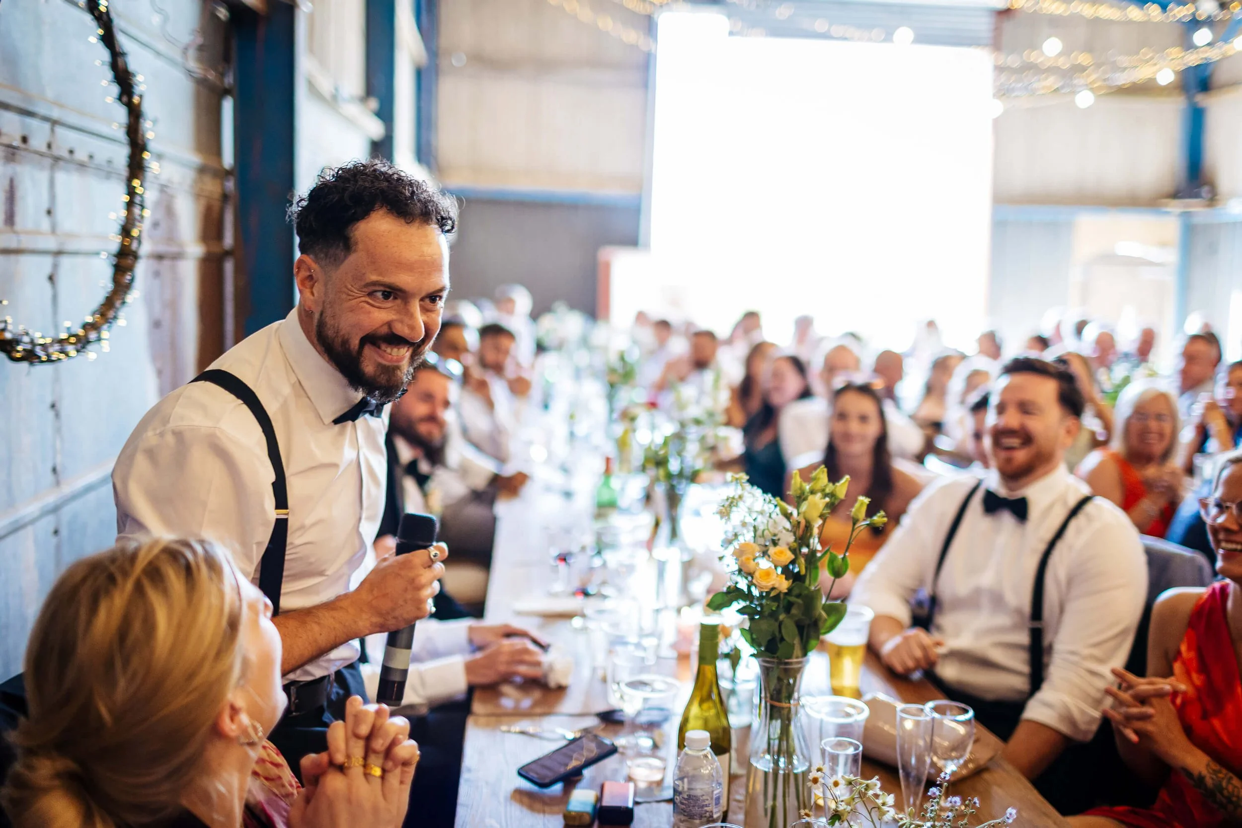 Guests laughing during the best mans speech at a wedding