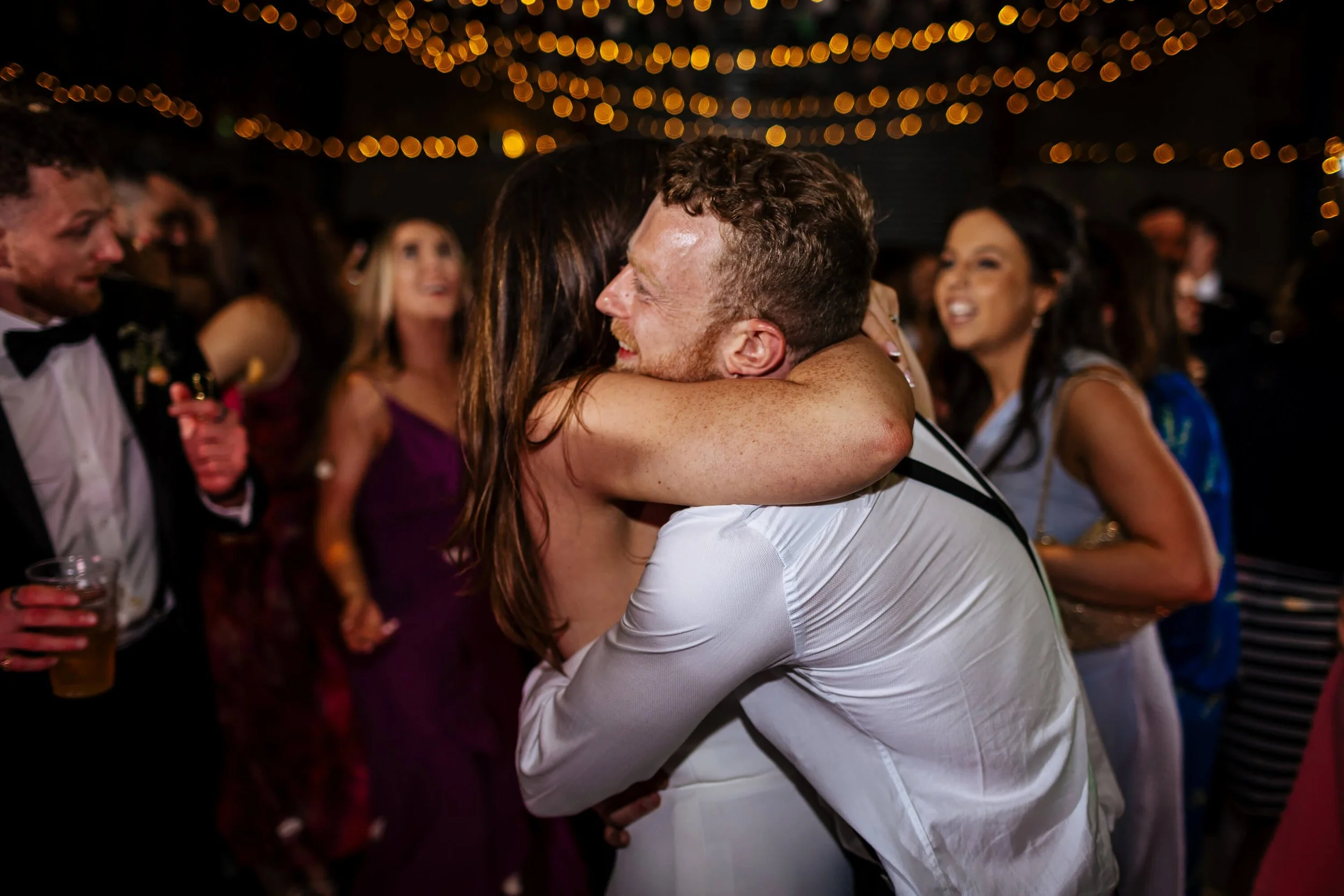 Bride and groom hug on the dance floor at their wedding