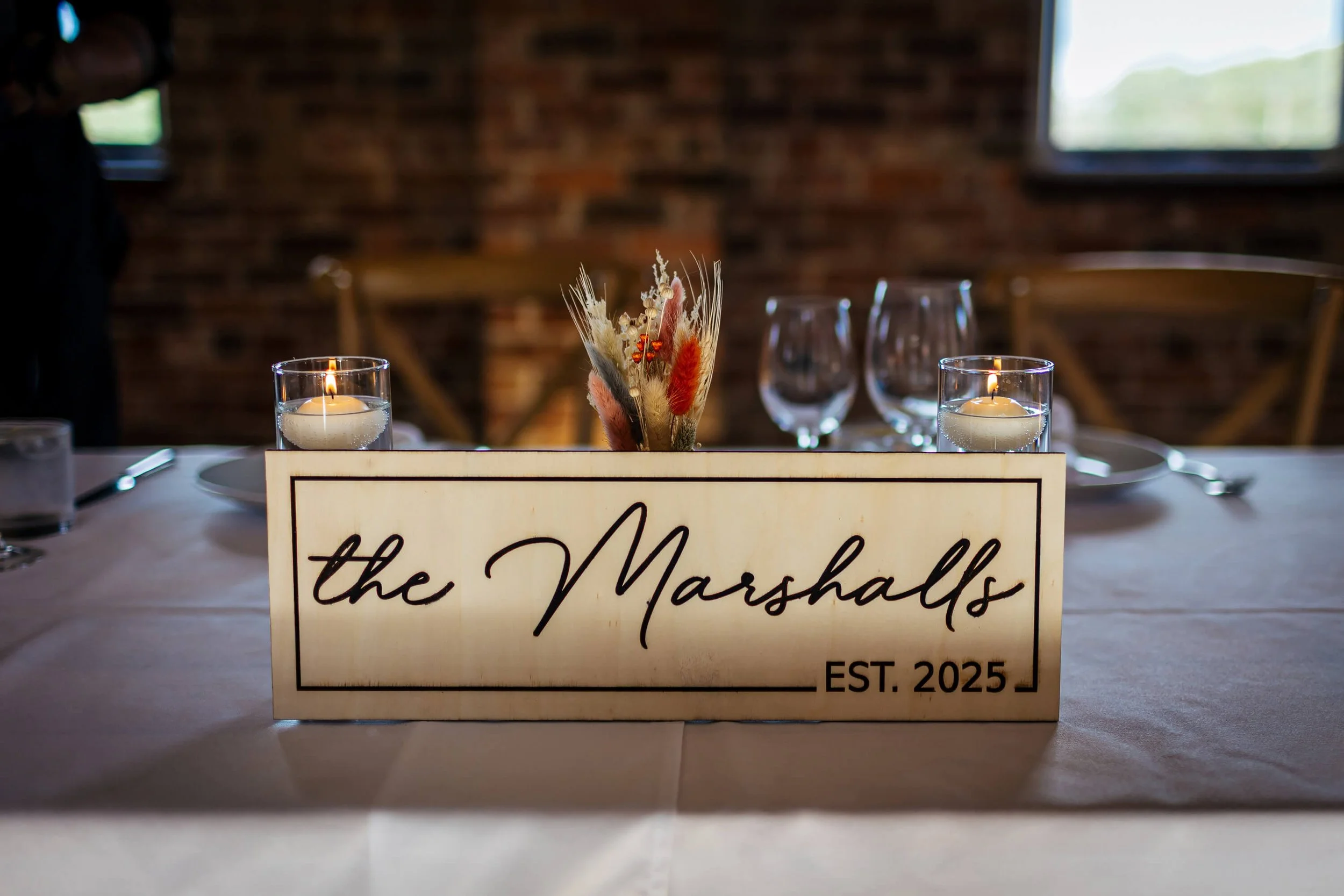Wooden sign that reads The Marshalls as a table decoration