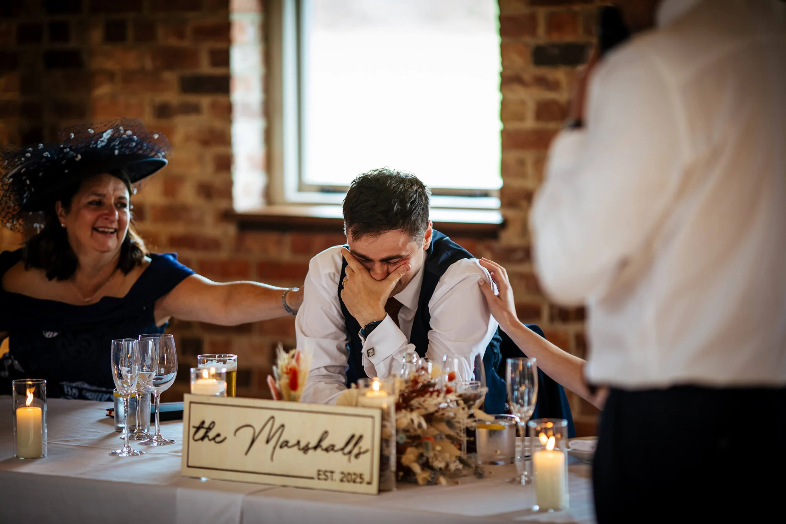 Groom with his head in his hands during the speeches