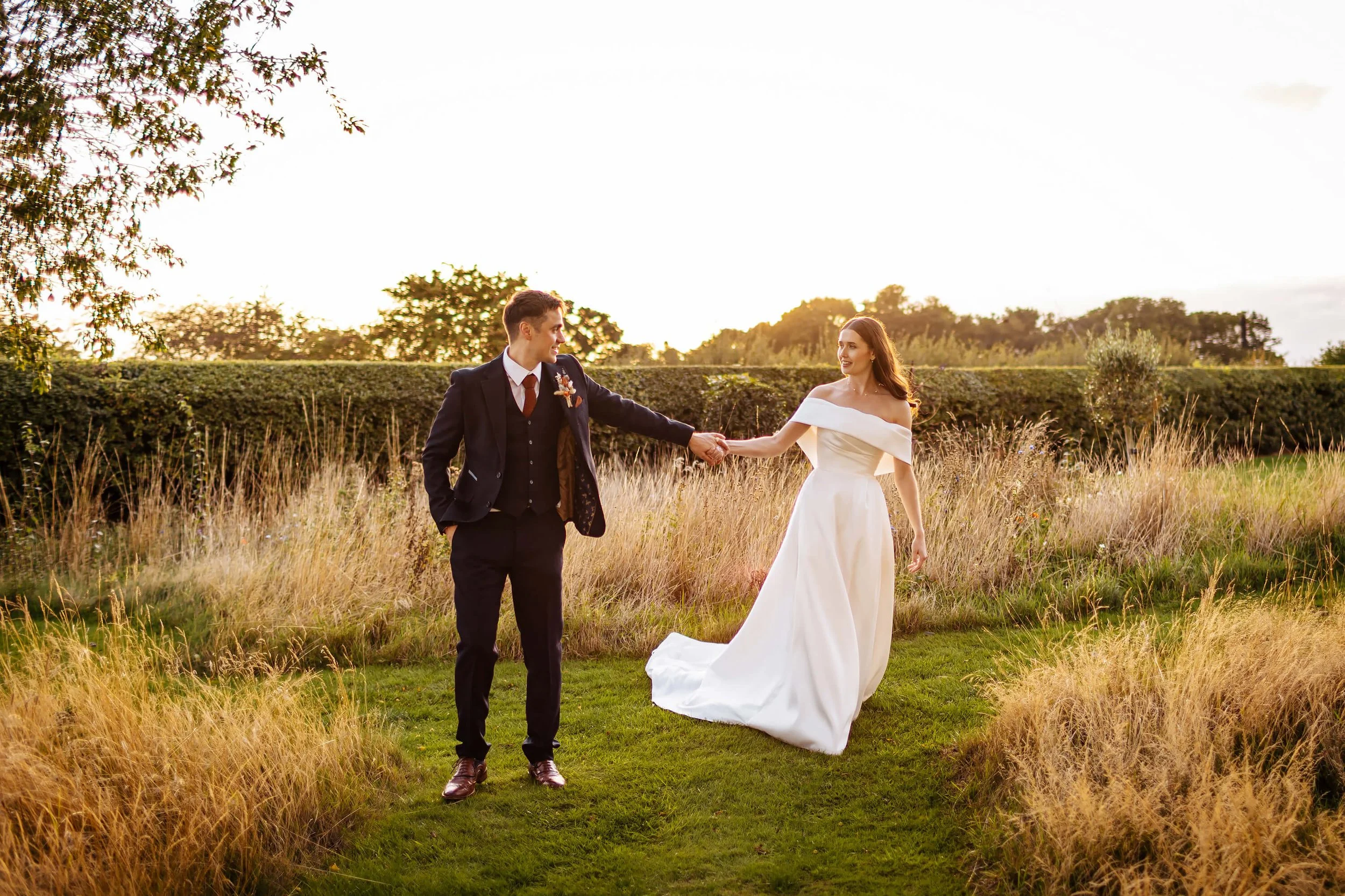 Bride and groom walking through the gardens on their wedding day