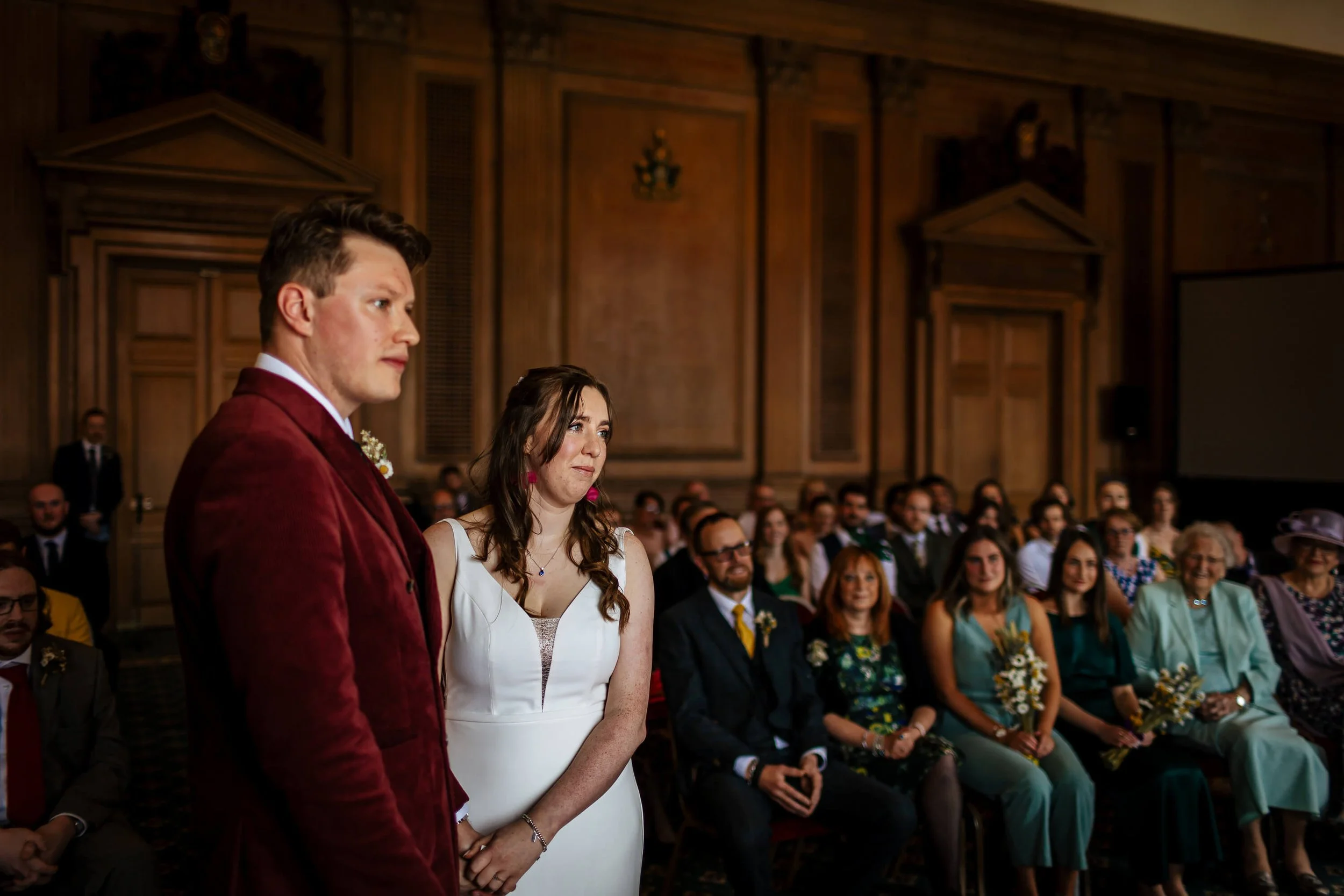 Bride and groom look on at the wedding celebrant