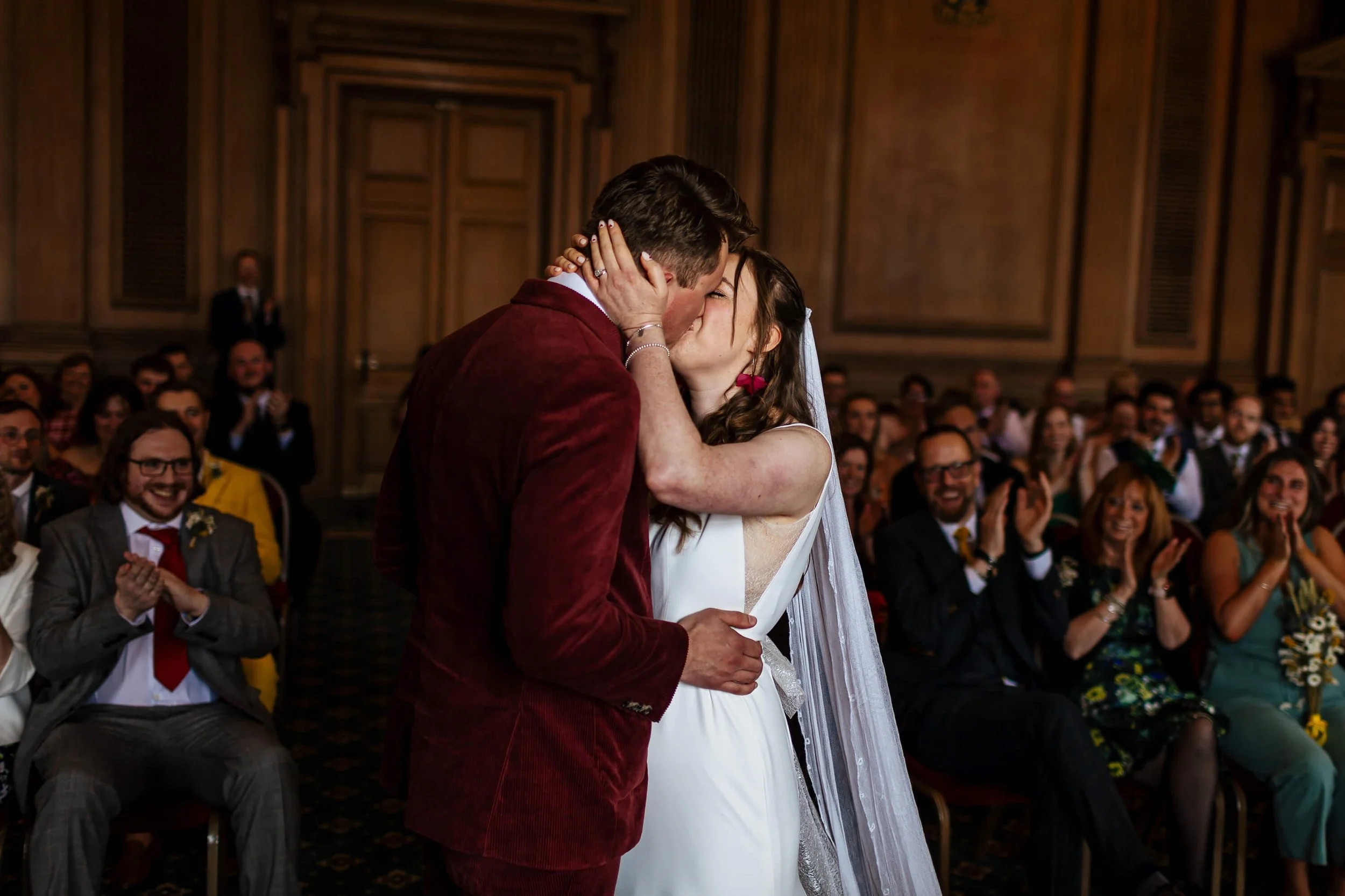 Bride and groom share their first kiss at the wedding