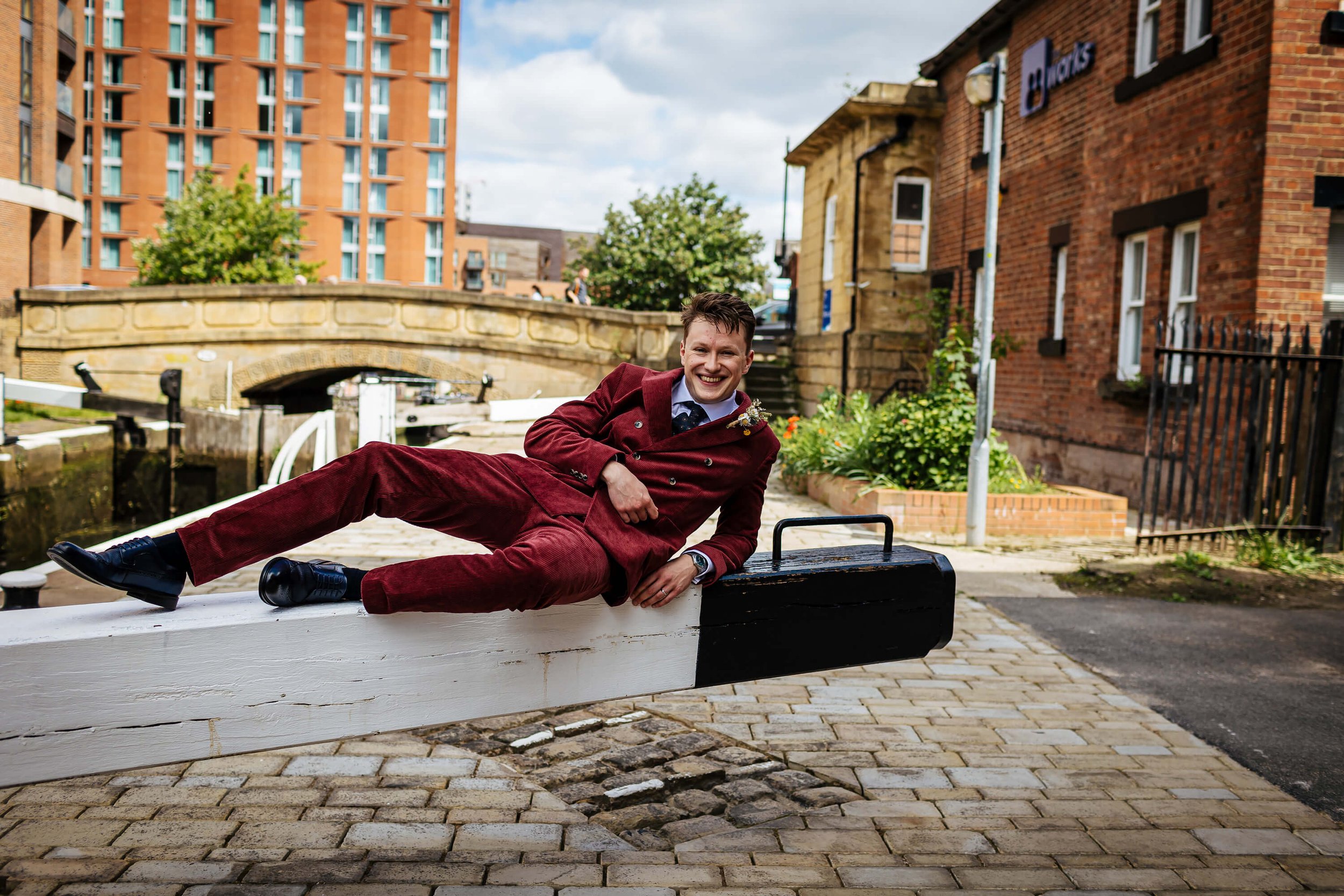 Groom lying on the lock barrier on Leeds canal