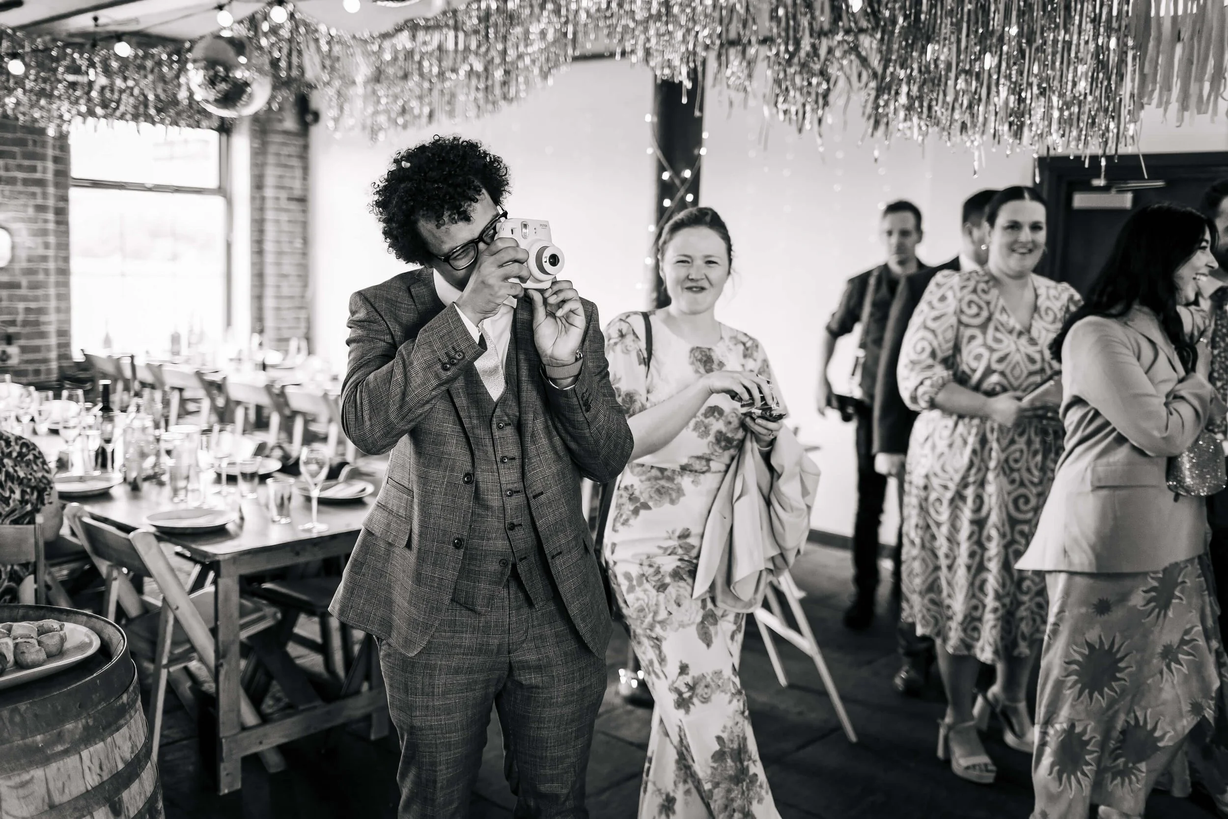 Wedding guest using a polarod camera