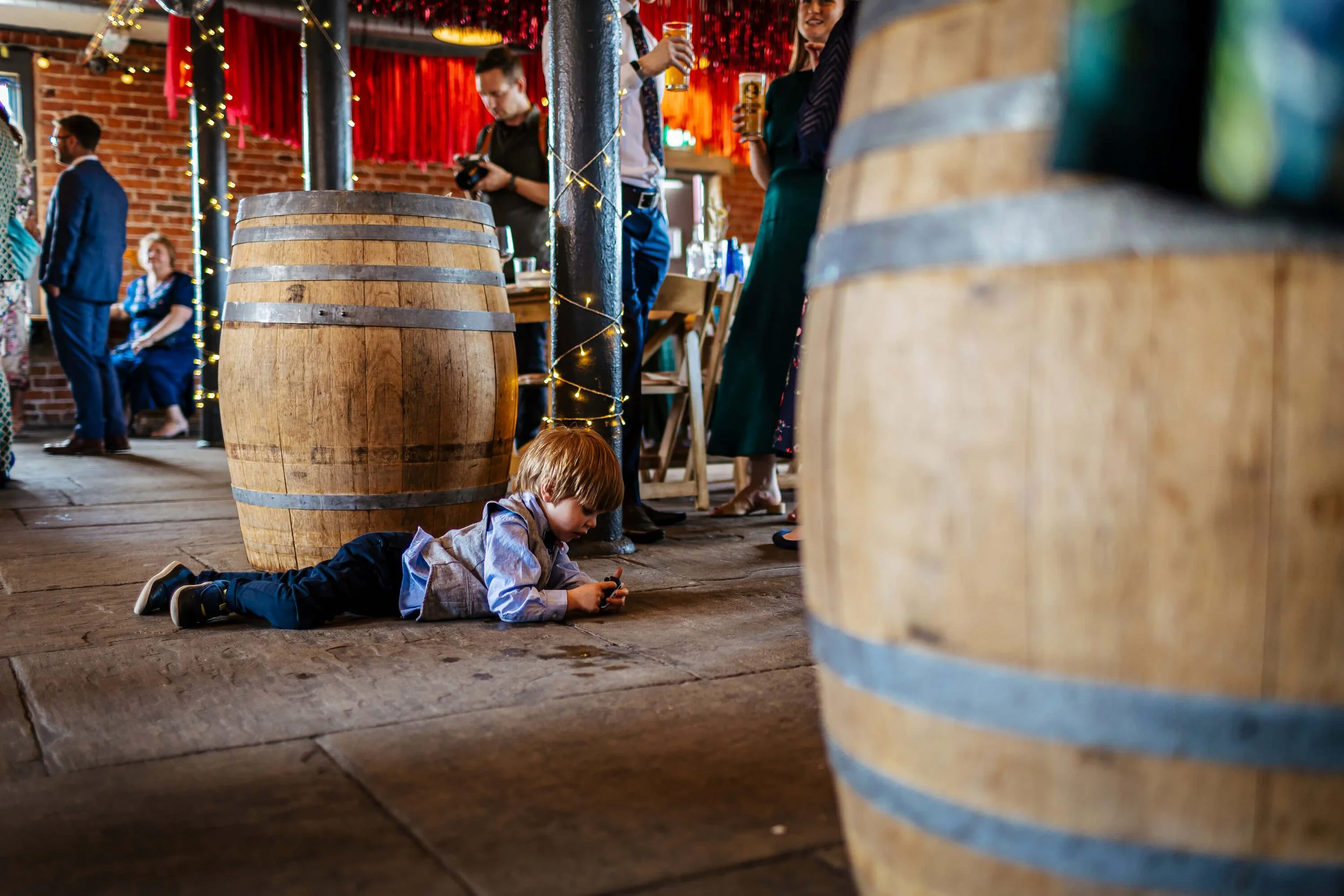 Young boy lying on the ground at a wedding reception