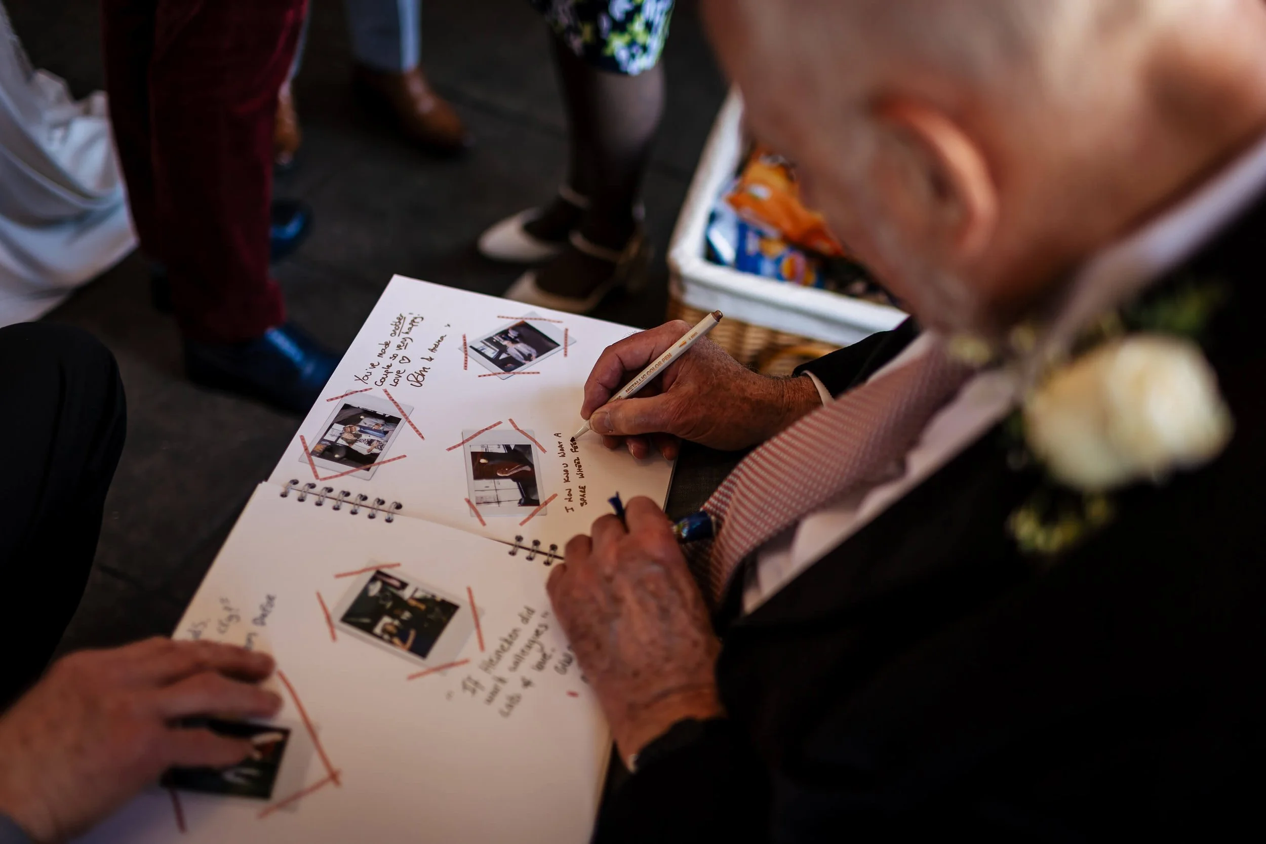 Wedding guests sign the guestbook with a polaroid photo