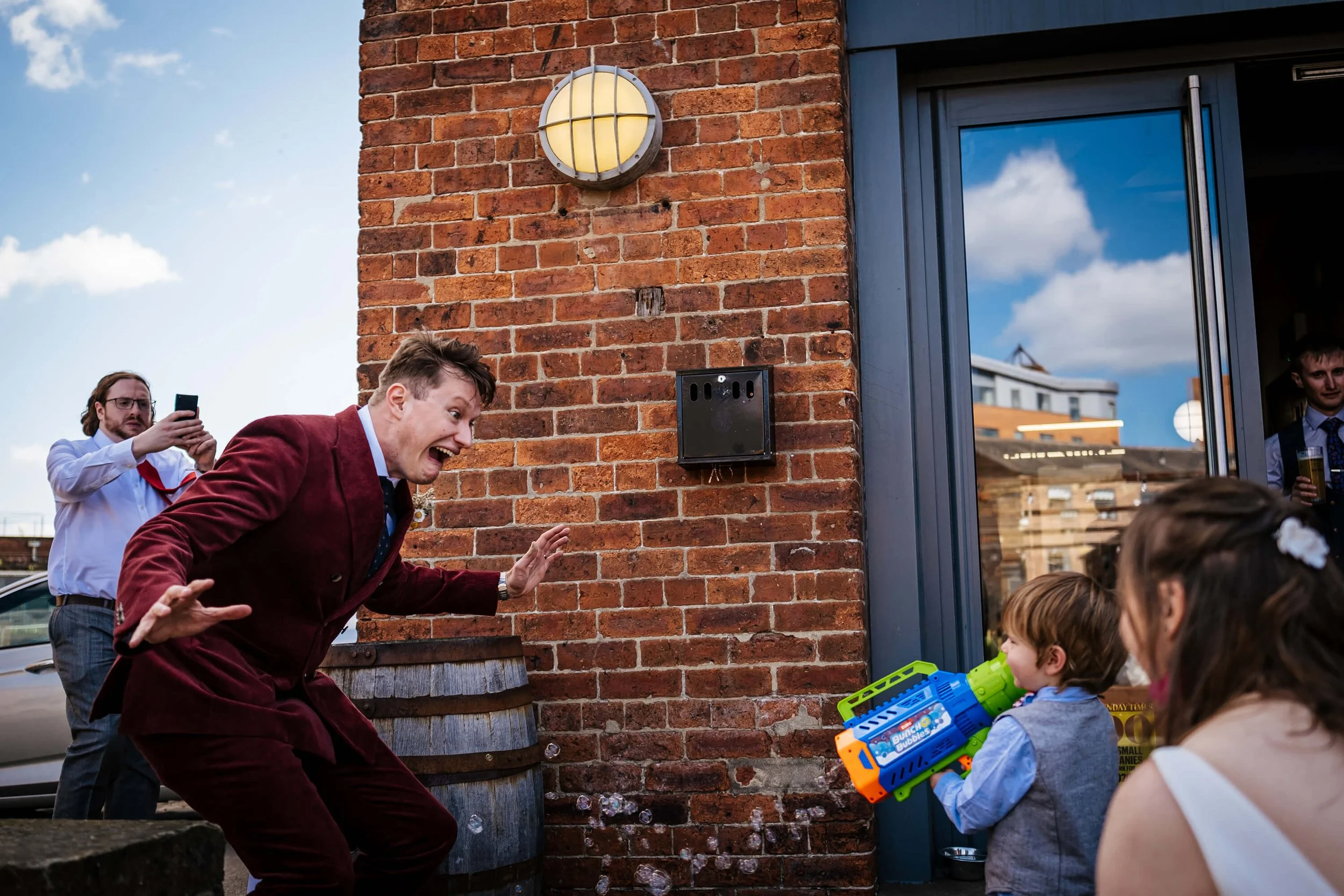 Groom playing with a young boy at his wedding