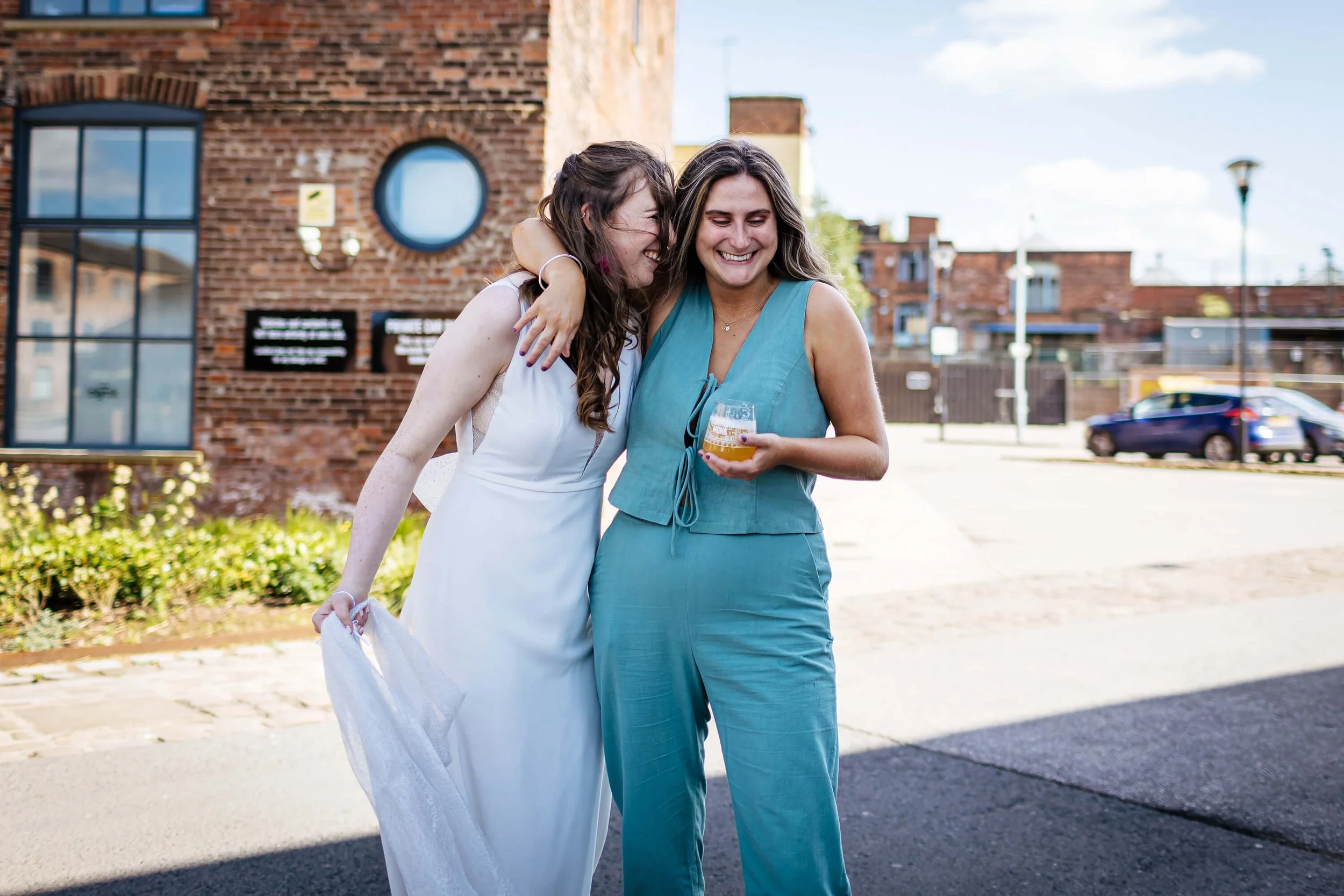 Bride laughing with her maid of honour at the wedding