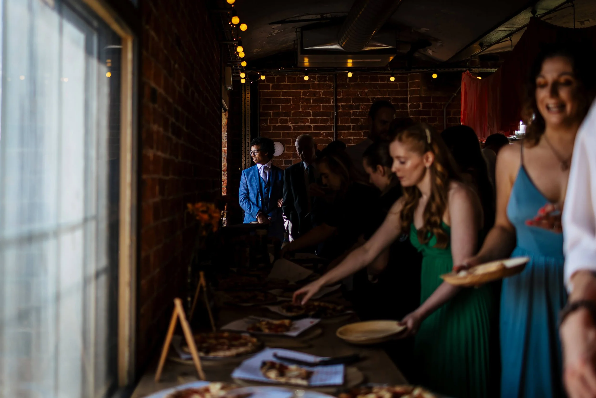 Wedding guests helping themselves to the pizza buffet