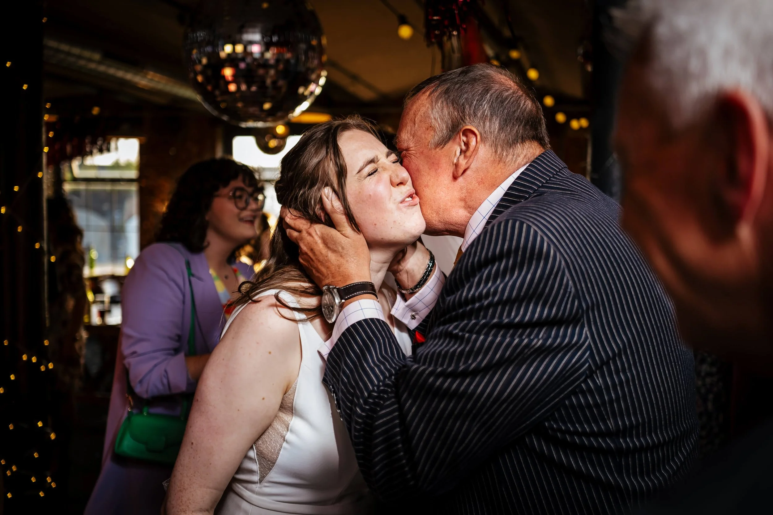 Wedding guest kisses the bride on her wedding day
