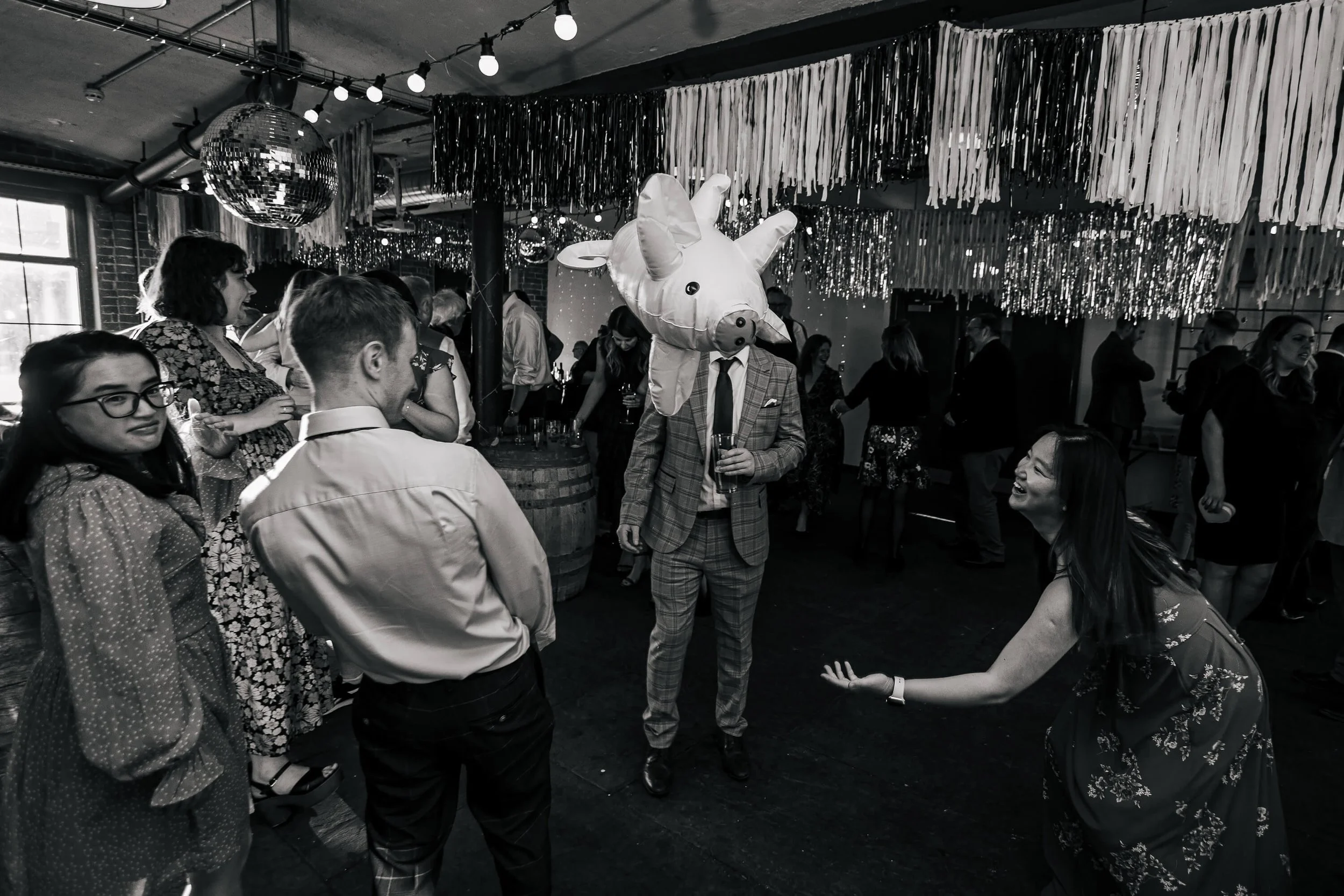 Guests throwing some giant inflatable pigs at a wedding