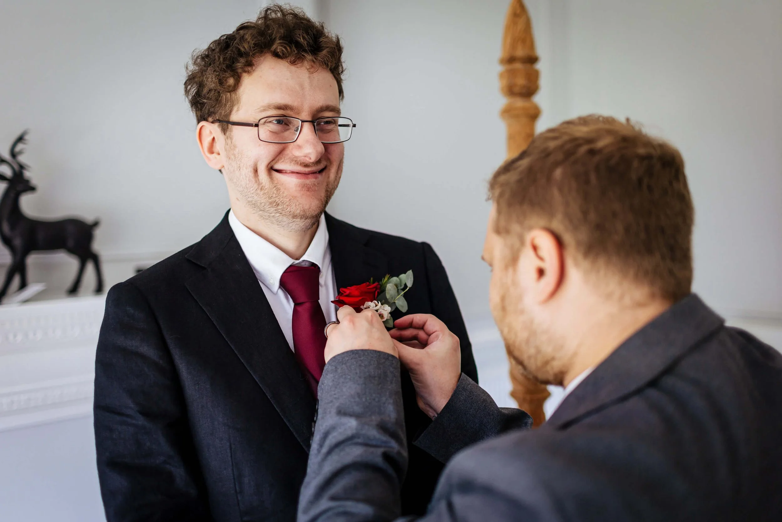 Groom has his buttonhole attached by his best man