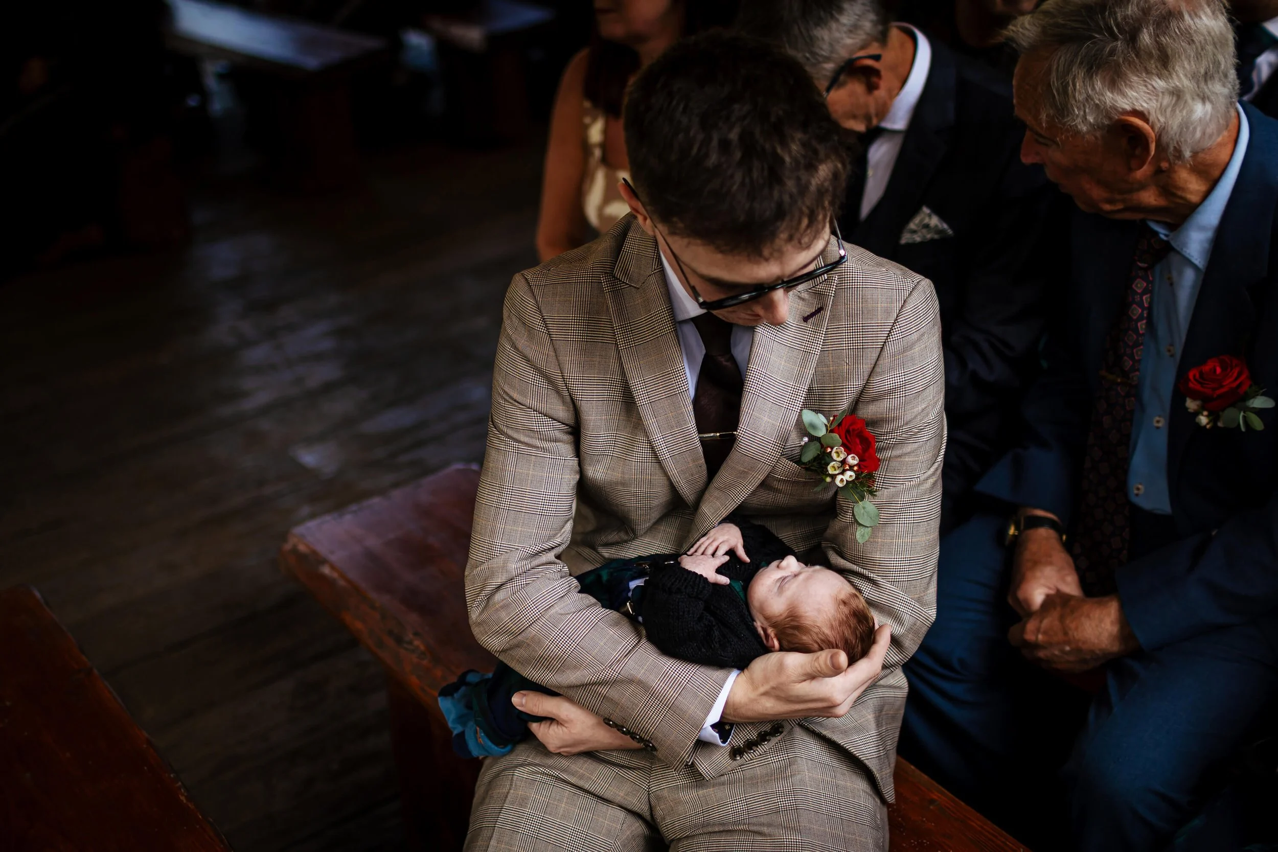 Wedding guest holding a newborn baby at the ceremony in Yorkshire