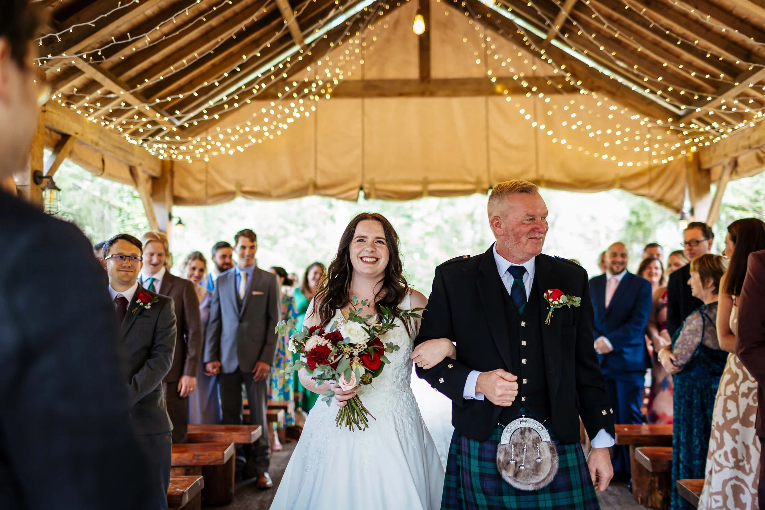 Bride walks down the aisle with her dad to her awaiting groom