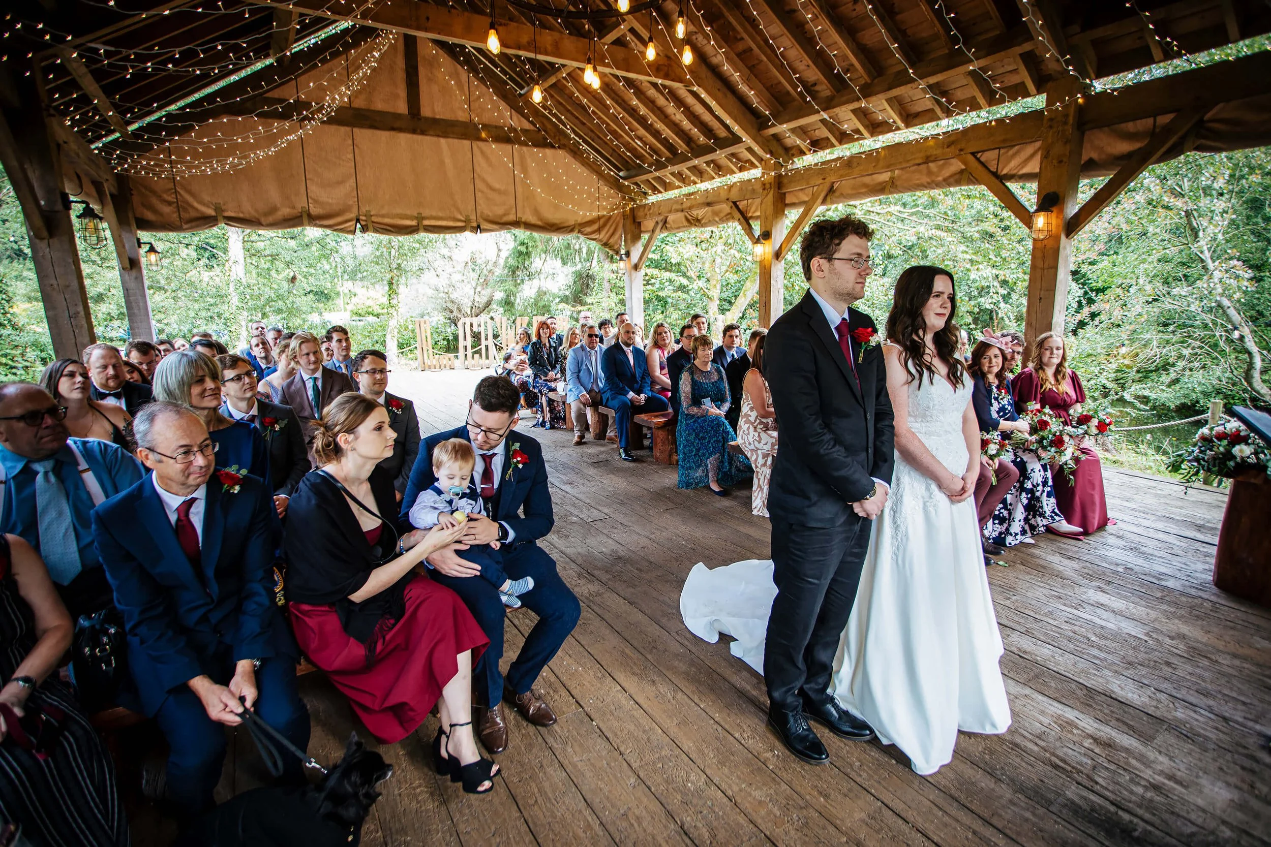 Wide shot of the wedding cermemony featuring the couple and all their guests