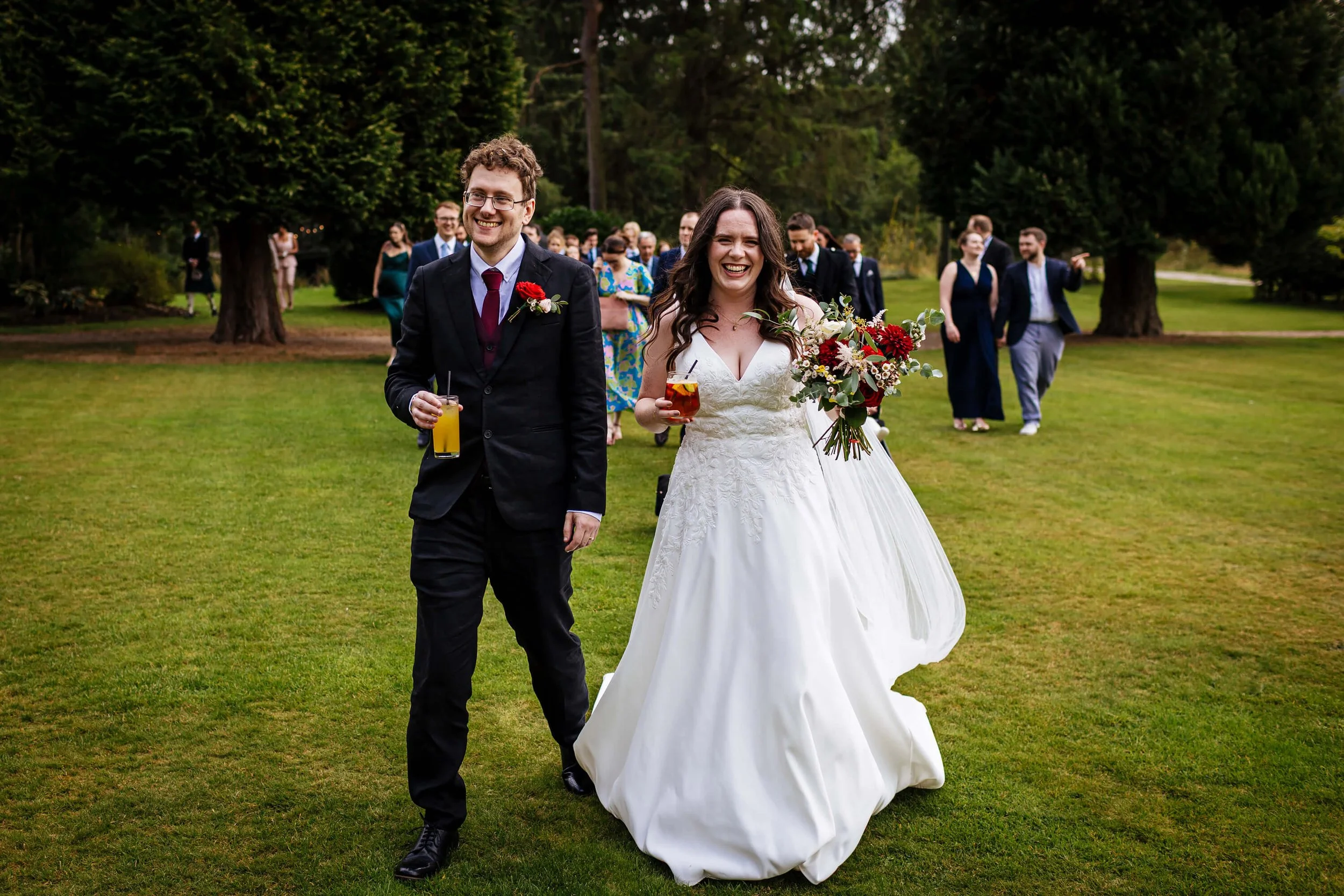 Bride and groom walking through the grounds of Hackness Grange
