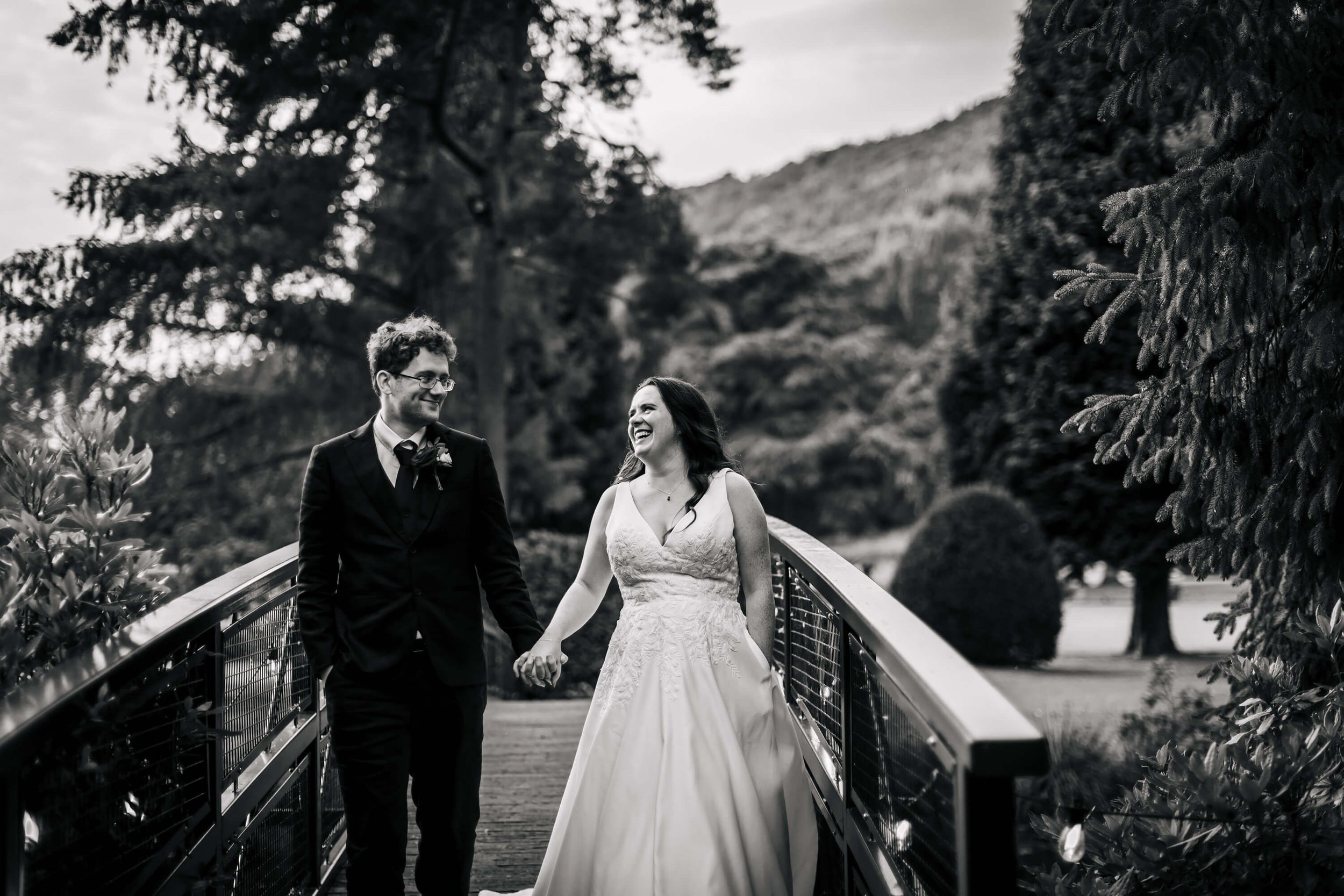 Bride and groom walking over the bridge on their wedding day