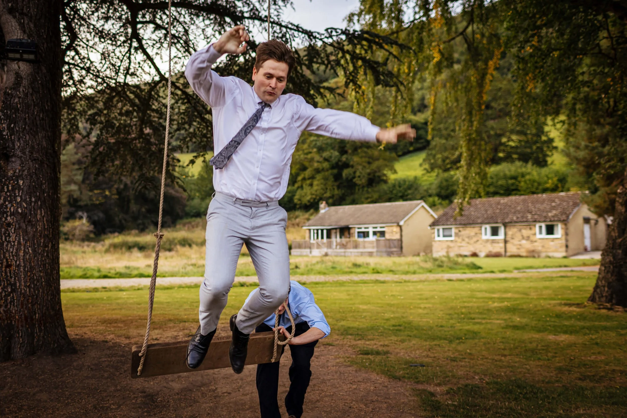 Wedding guests jumping off a swing during the reception