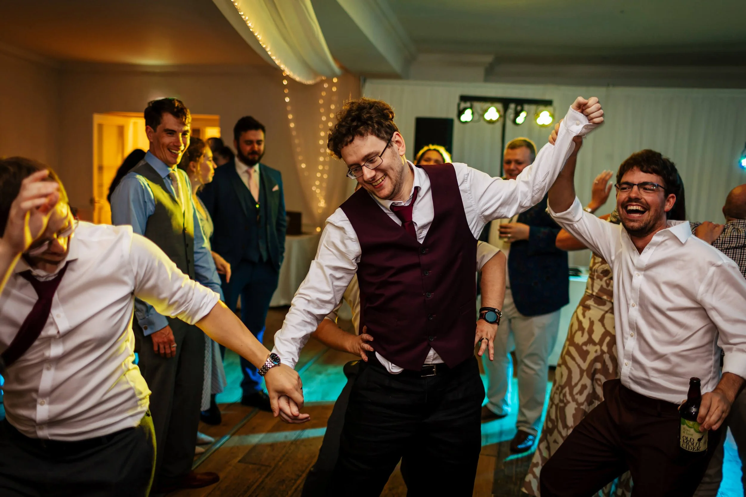 Groomsmen helping the groom dance at his wedding