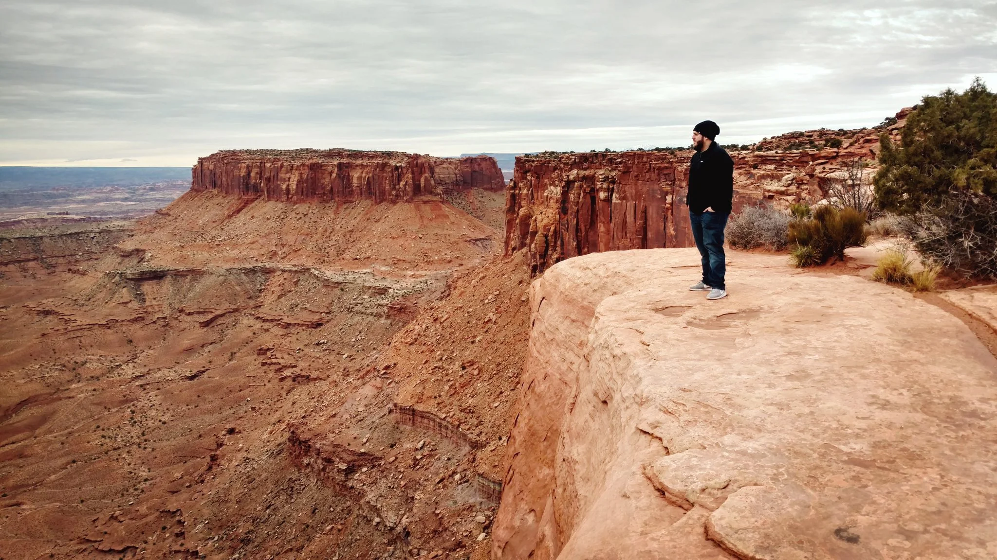 Ryan L. Smith standing on a cliff overlooking desert canyons in Utah.